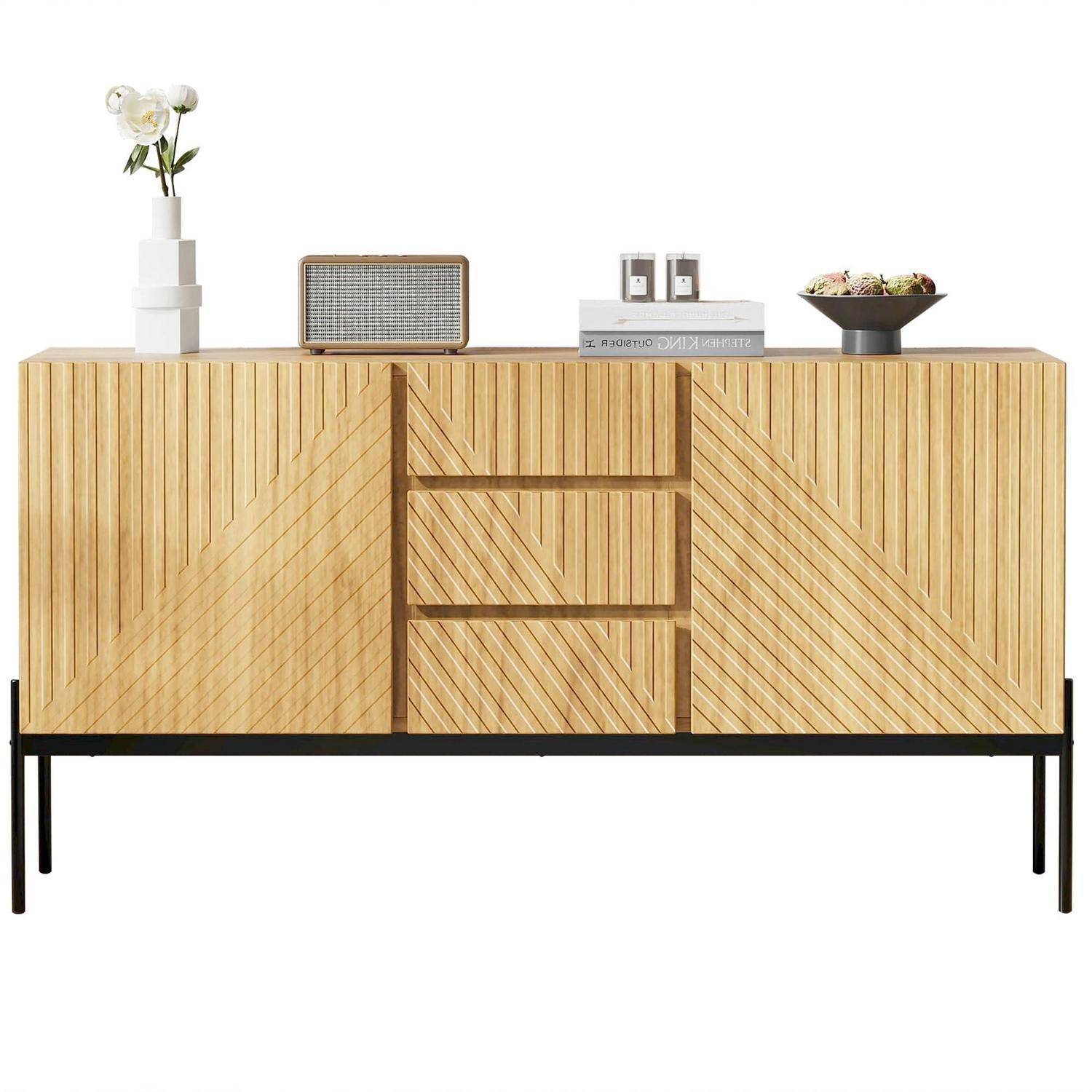 Helles Holz-Sideboard mit geometrischen Chevron-Türfronten und schwarzen Metallfüßen, belegt mit einer Vase, einem Radio, Büchern, Gläsern und einer Schüssel.