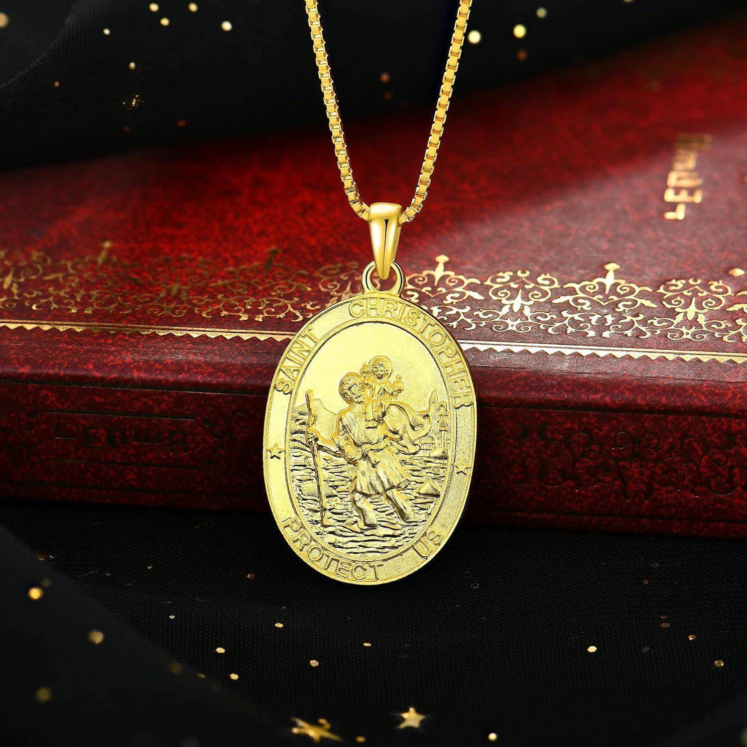 Goldene Medaille des Heiligen Christophorus als Anhänger an einer Kette, ruhend auf einer roten dekorativen Schachtel vor schwarzem Hintergrund.