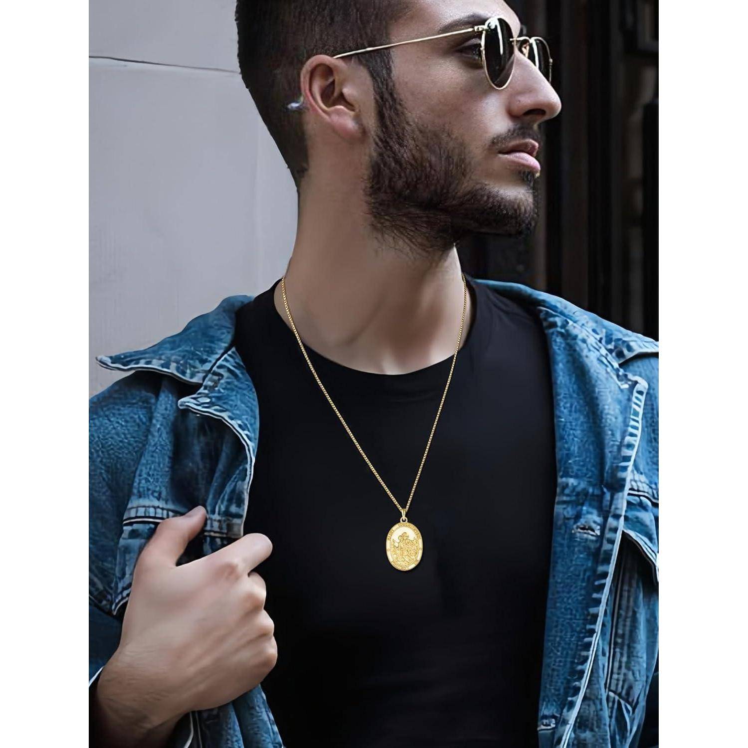 Junger Mann mit Sonnenbrille und Jeansjacke, der eine goldene Anhängerkette trägt und nach draußen blickend zur Seite schaut.