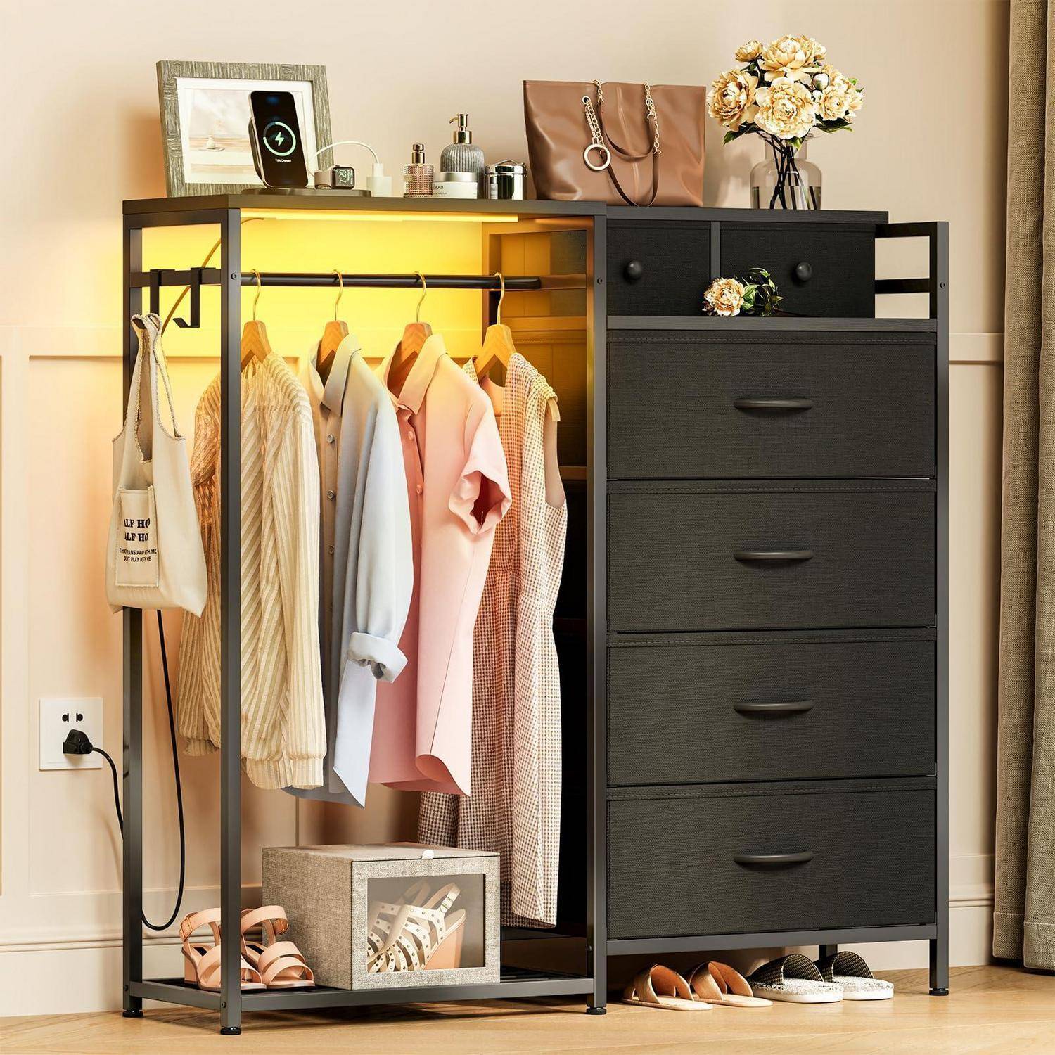 Offener Kleiderschrank und Kommode mit hängender Kleidung, Schubladen und Accessoires in einem aufgeräumten Schlafzimmer.