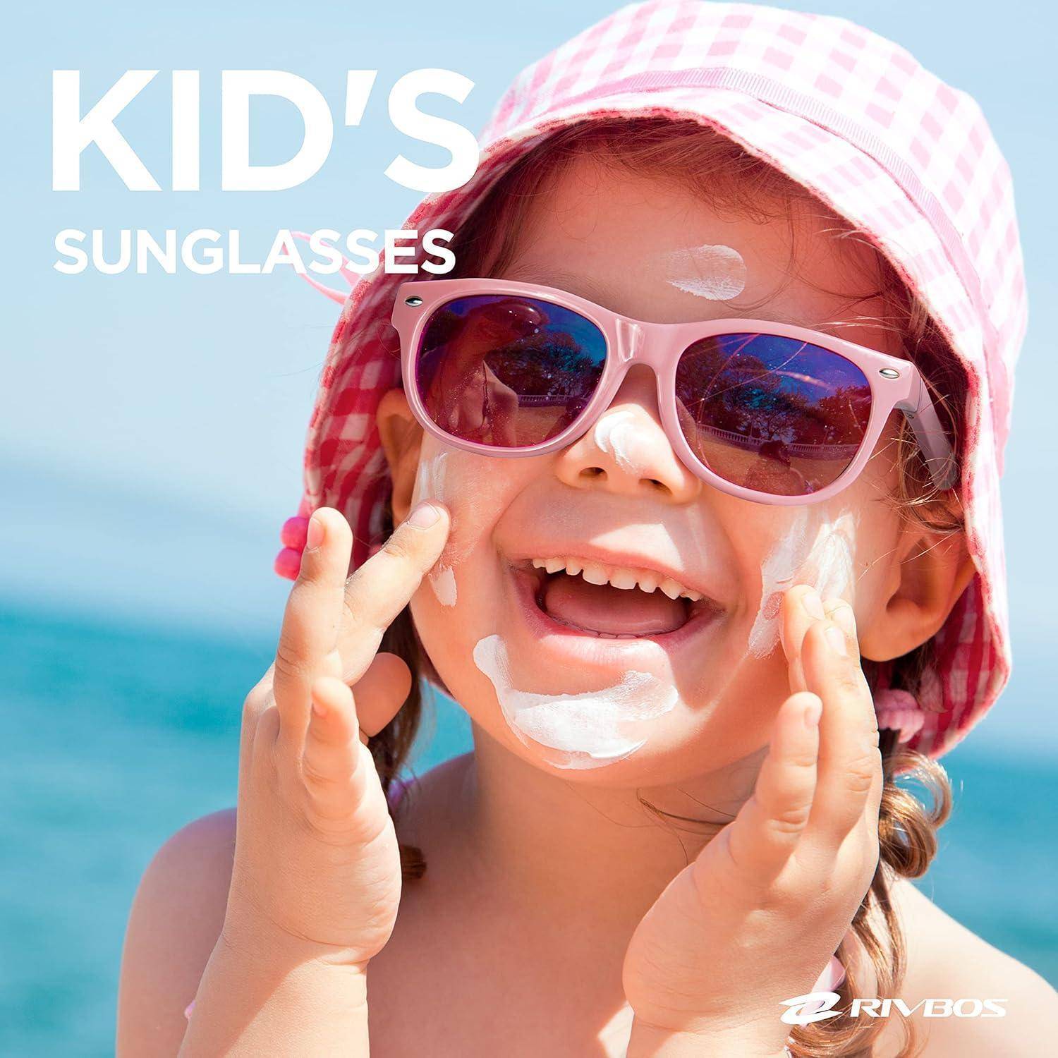 Lachendes Kind, das rosa Sonnenbrille und einen Sonnenhut am Strand trägt, mit dem Text „KID'S SUNGLASSES" in der Ecke.