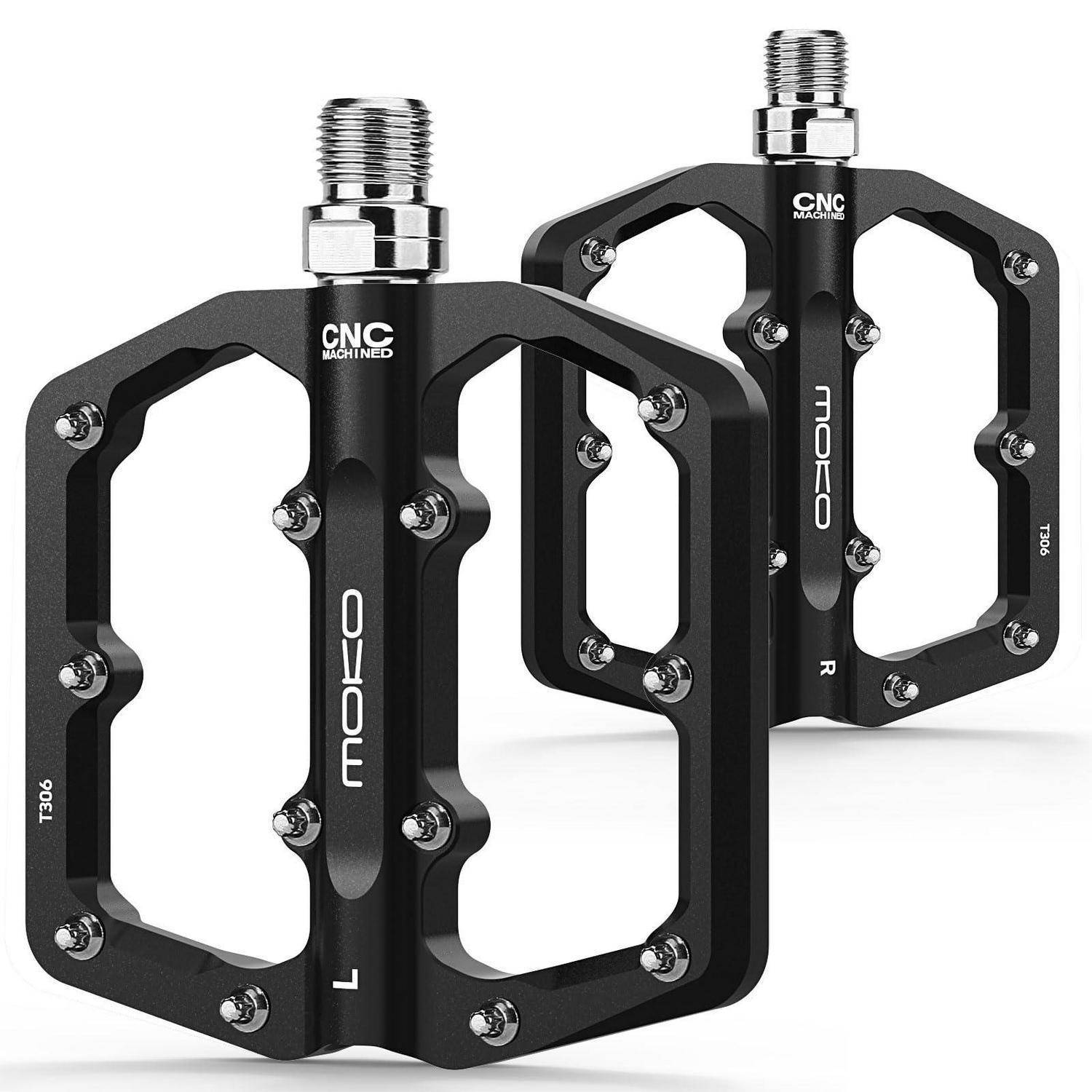 Zwei schwarze CNC-gefräste Fahrradpedale mit silbernen Gewindewellen, auf weißem Hintergrund abgebildet.
