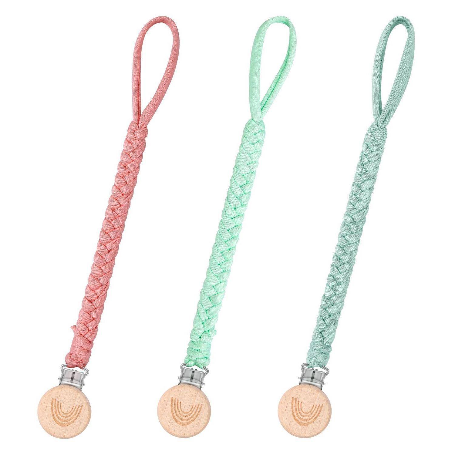 Drei geflochtene Schnullerketten in Rosa, Mint und Salbei, jede mit einer Holzknopfverschluss und einer Stoffschlaufe.