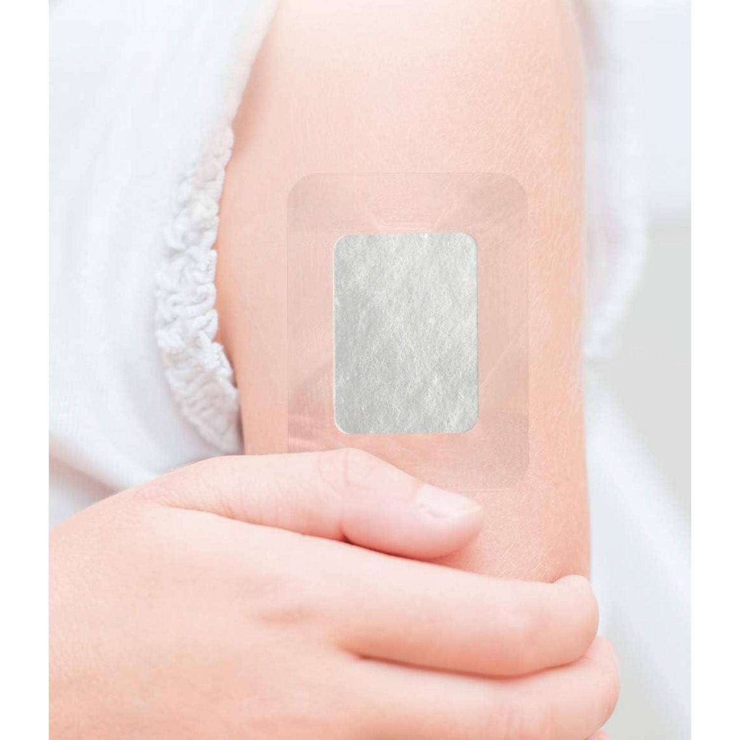 Nahaufnahme des Oberarms einer Person mit einem kleinen quadratischen Haftpflaster oder Verband.