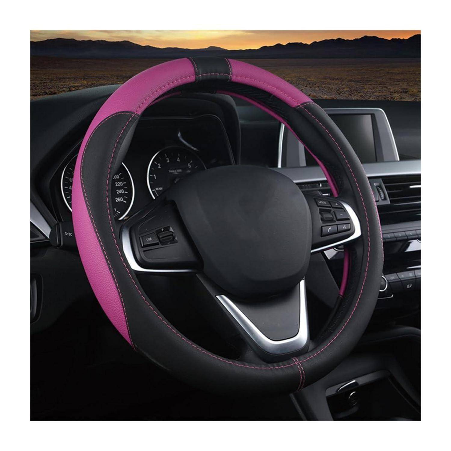 Rosa-schwarze Lenkradabdeckung auf einem Autolenkrad, gezeigt über einem Armaturenbrett-Innenraum bei Sonnenuntergang.