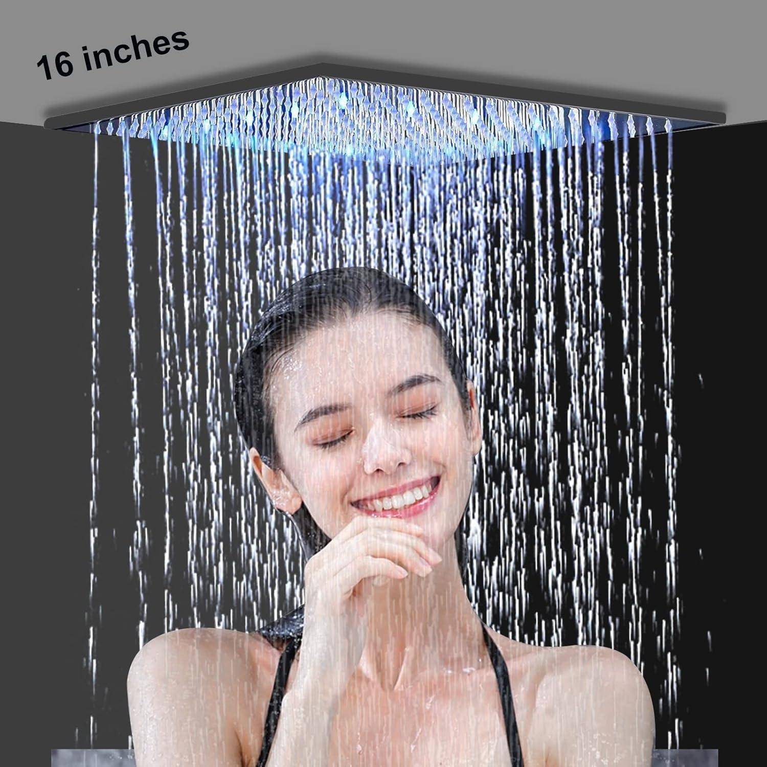 Eine Frau lächelt unter einer quadratischen Regenduschkopf mit der Bezeichnung 16 Zoll, wobei Wasser über ihr Gesicht und ihre Schultern strömt.