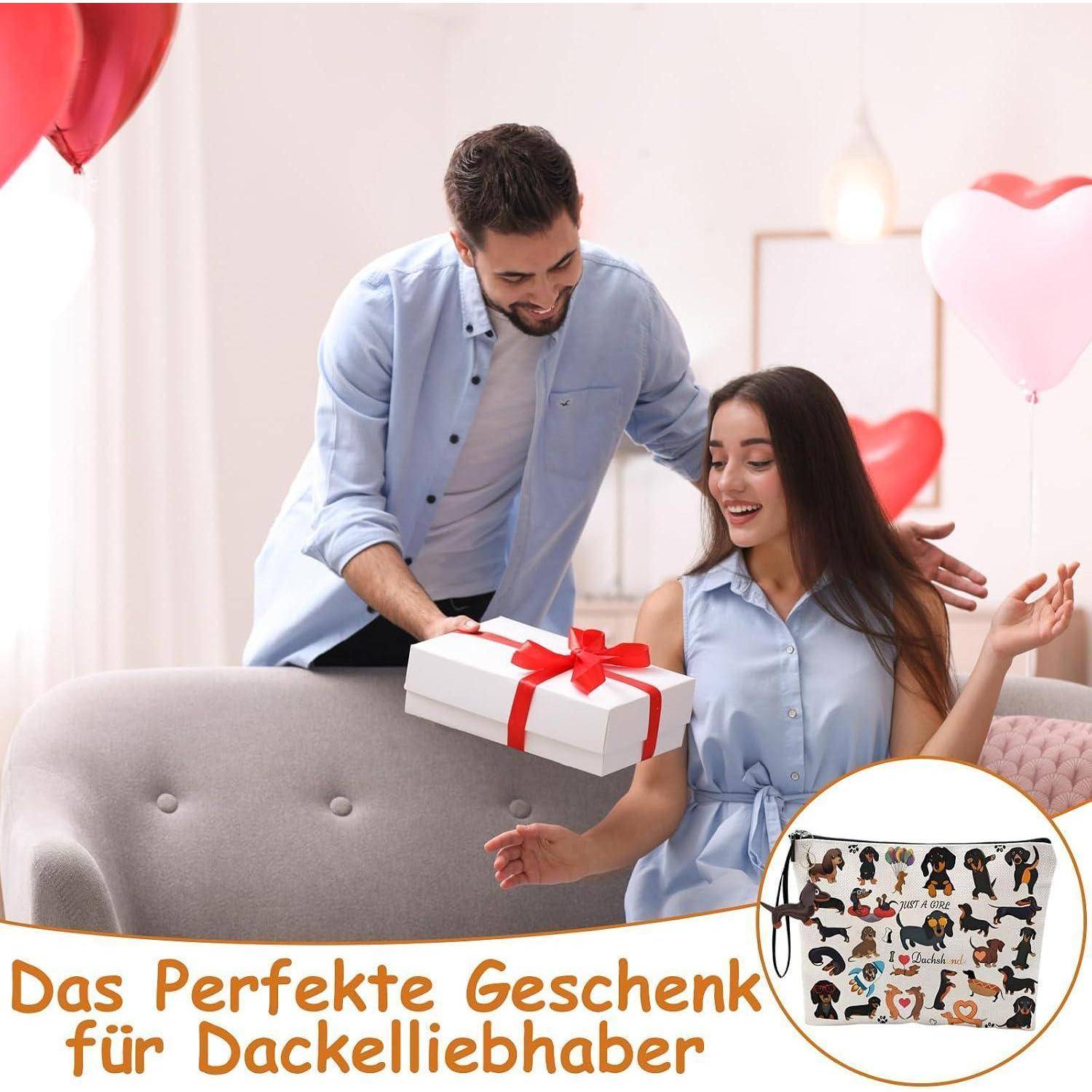 Ein Mann präsentiert einer sitzenden Frau ein verpacktes Geschenk inmitten von herzförmigen Ballons; Deutscher Text liest 