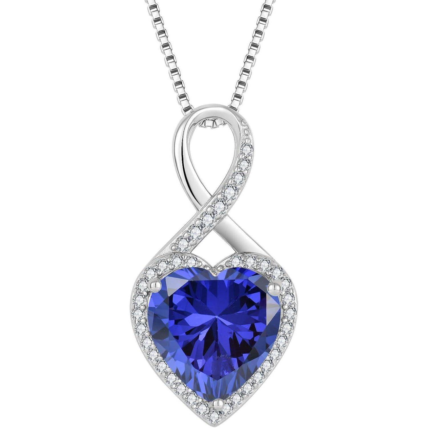 Silberkette mit einem unendlichkeitsförmigen Anhänger, der einen blaugeschliffenen Herzstein umfasst, umgeben von kleinen klaren Steinen.