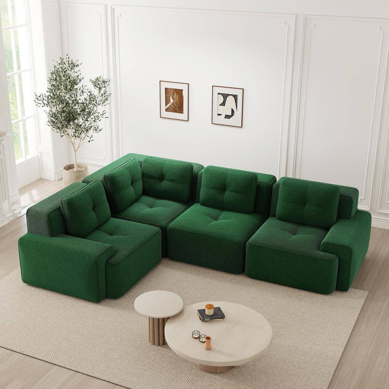 Grünes modulares Sofa mit Eckelementen, das um zwei runde Couchtische in einem hellen minimalistischen Wohnzimmer mit gerahmten Wandbildern und einem Topfbaum angeordnet ist.