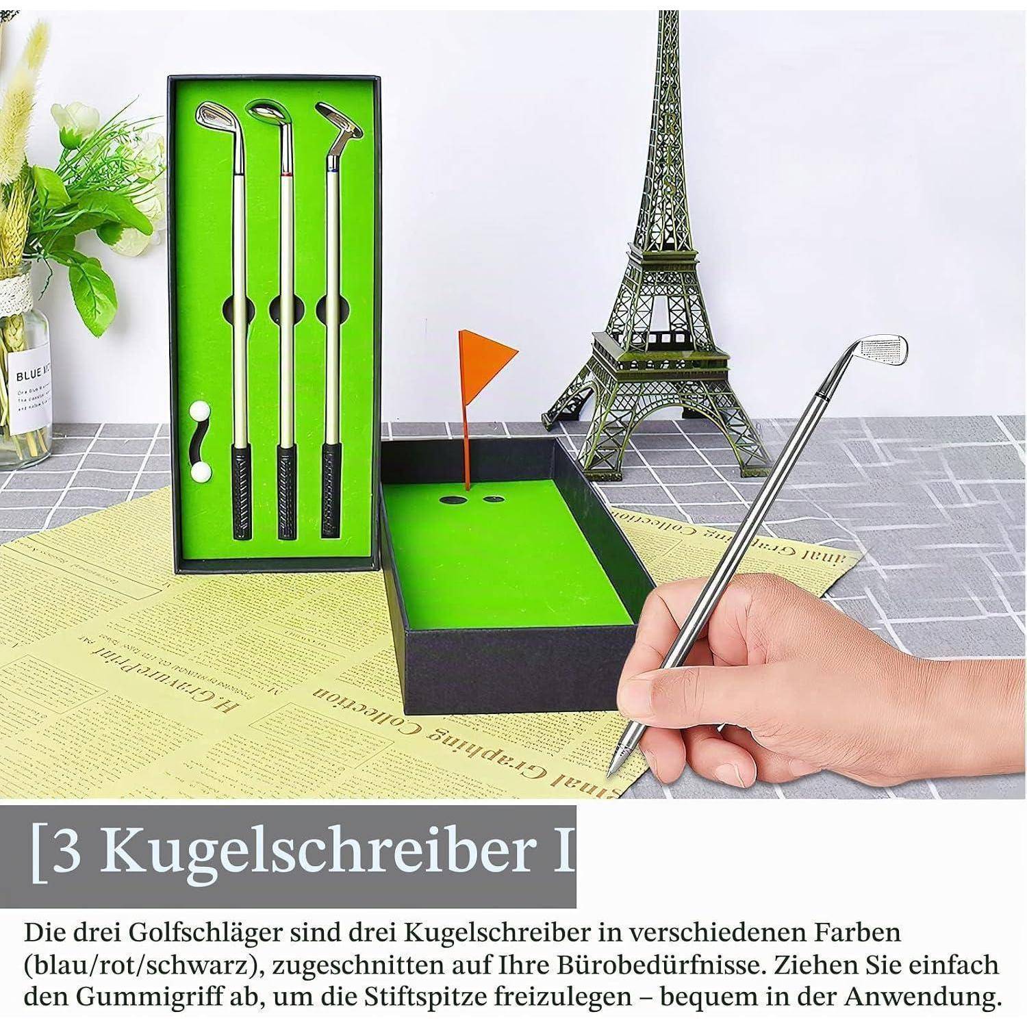 Hand hält einen golfschlägerförmigen Stift über einem Miniatur-Putting-Green mit drei passenden Stiften, die in einer Box ausgestellt sind, und dem Eiffelturm im Hintergrund.