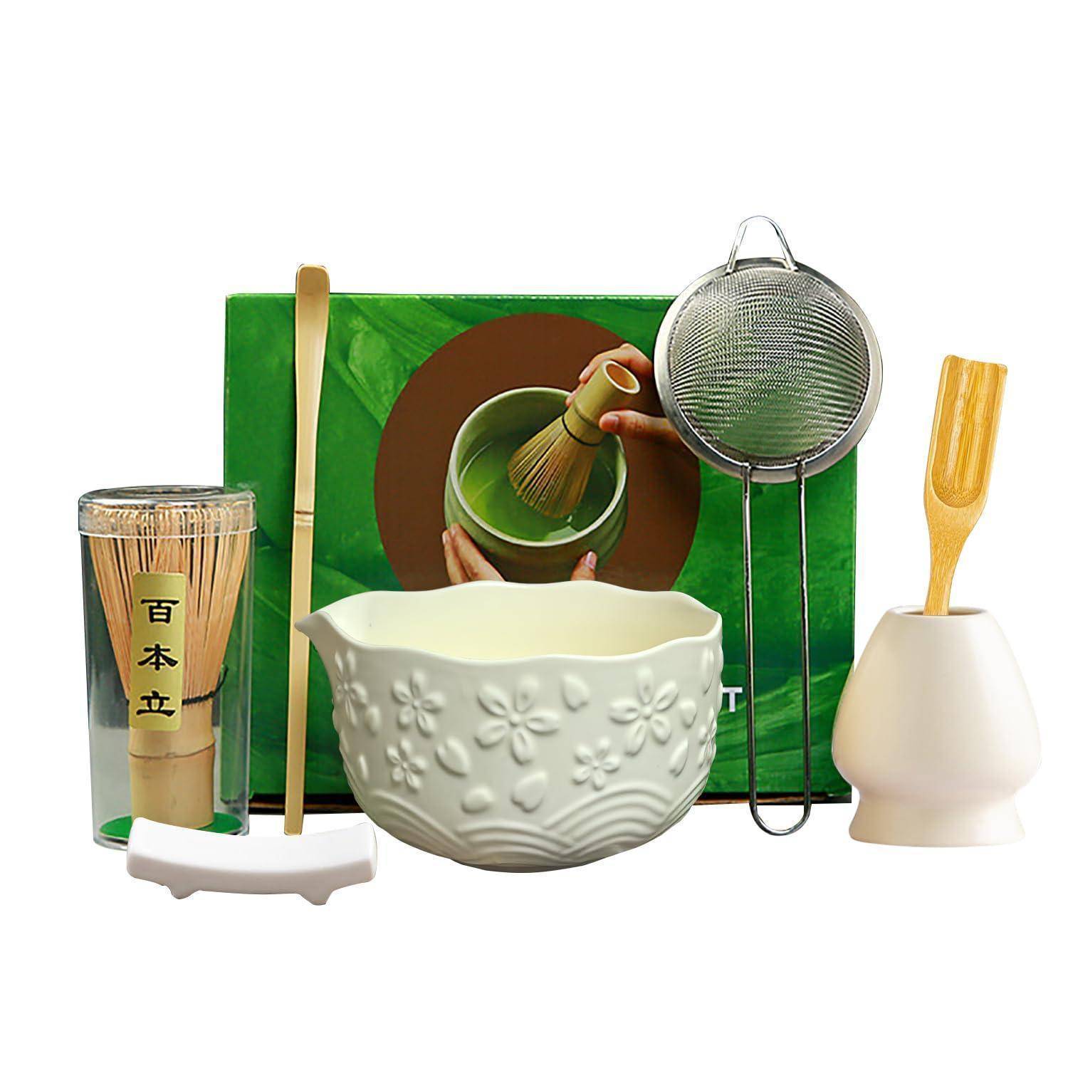 Matcha-Teezeremonie-Set mit Bambusbesen, Löffel, Sieb, Schüssel und Keramikhaltern, angeordnet vor einer grünen Schachtel