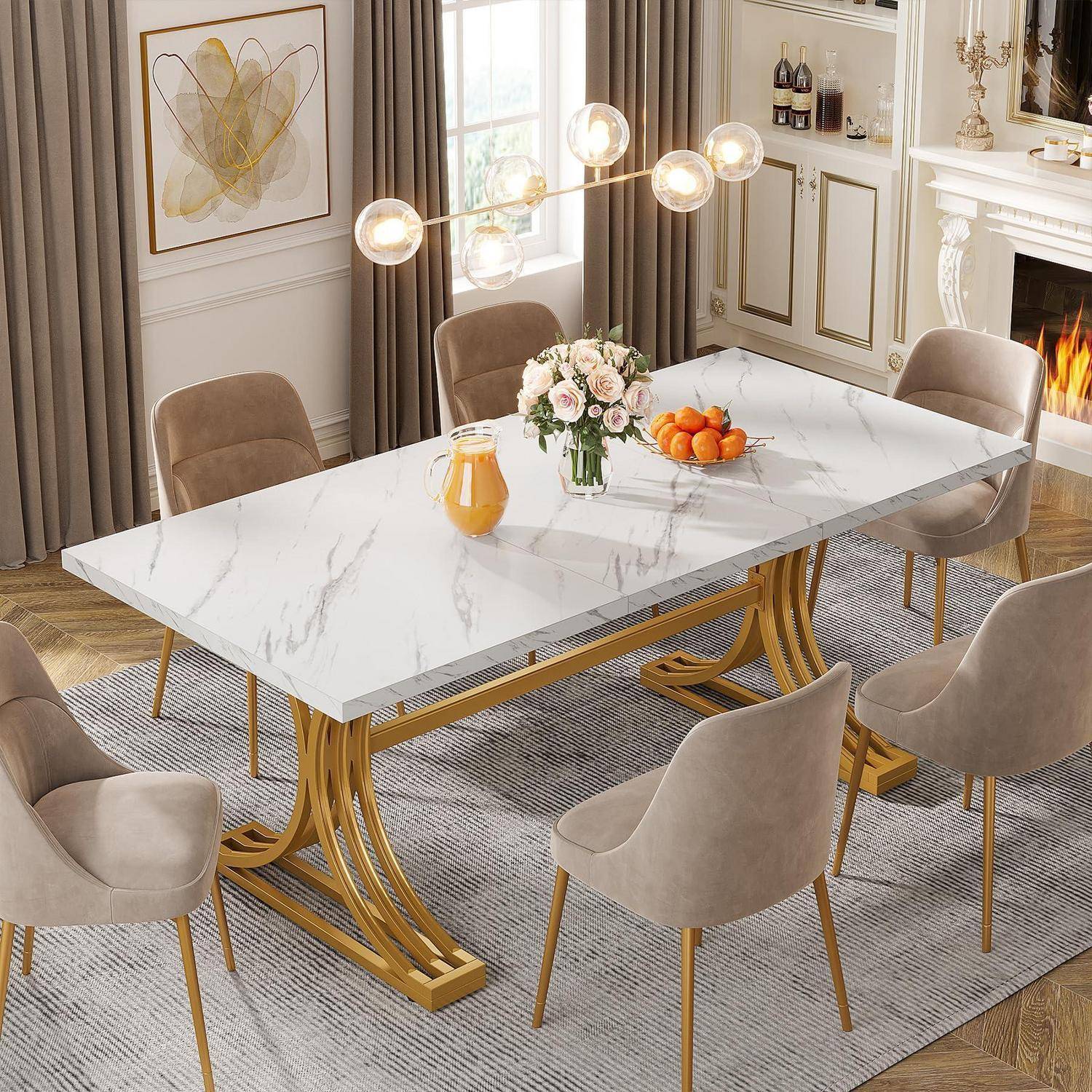 Modernes Esszimmer mit einem Tisch mit weißer Marmorplatte, sechs beige gepolsterten Stühlen mit goldenem Gestell, einer Blumenvase, einer Obstschale und einem brennenden Kamin in der Nähe.