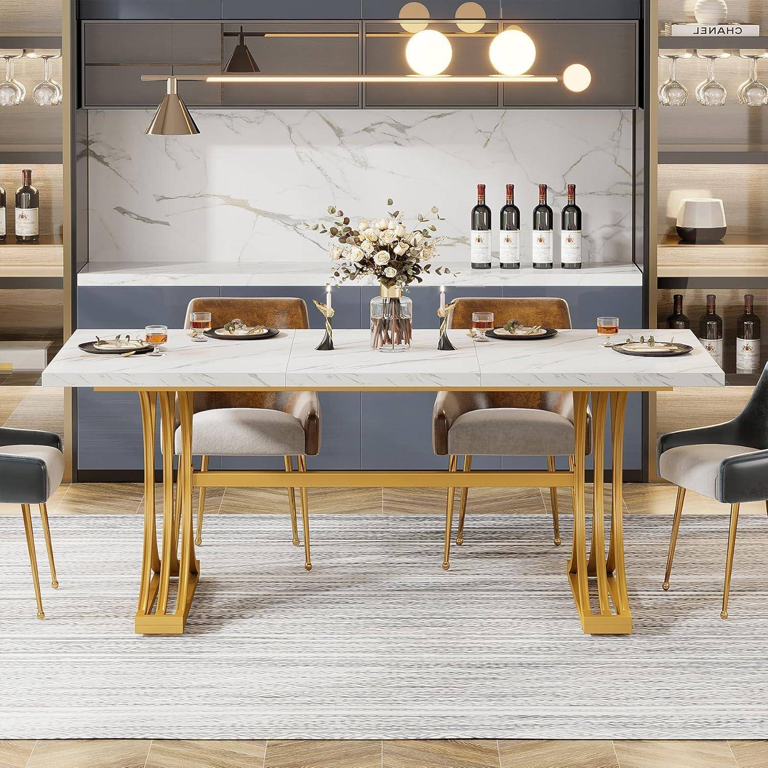 Modernes Esszimmer mit einem weißen Marmortisch für vier Personen, goldenen Stühlen, Pendelleuchten und einem Wandregal mit Weinflaschen und Dekorationselementen.