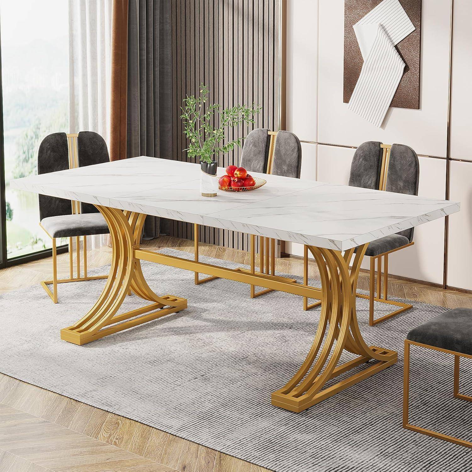 Moderner Esstisch mit weiß marmorähnlicher Tischplatte und geschwungener Sockelbasis in Gold, umgeben von gepolsterten grau-schwarzen Stühlen in einem hellen Raum.