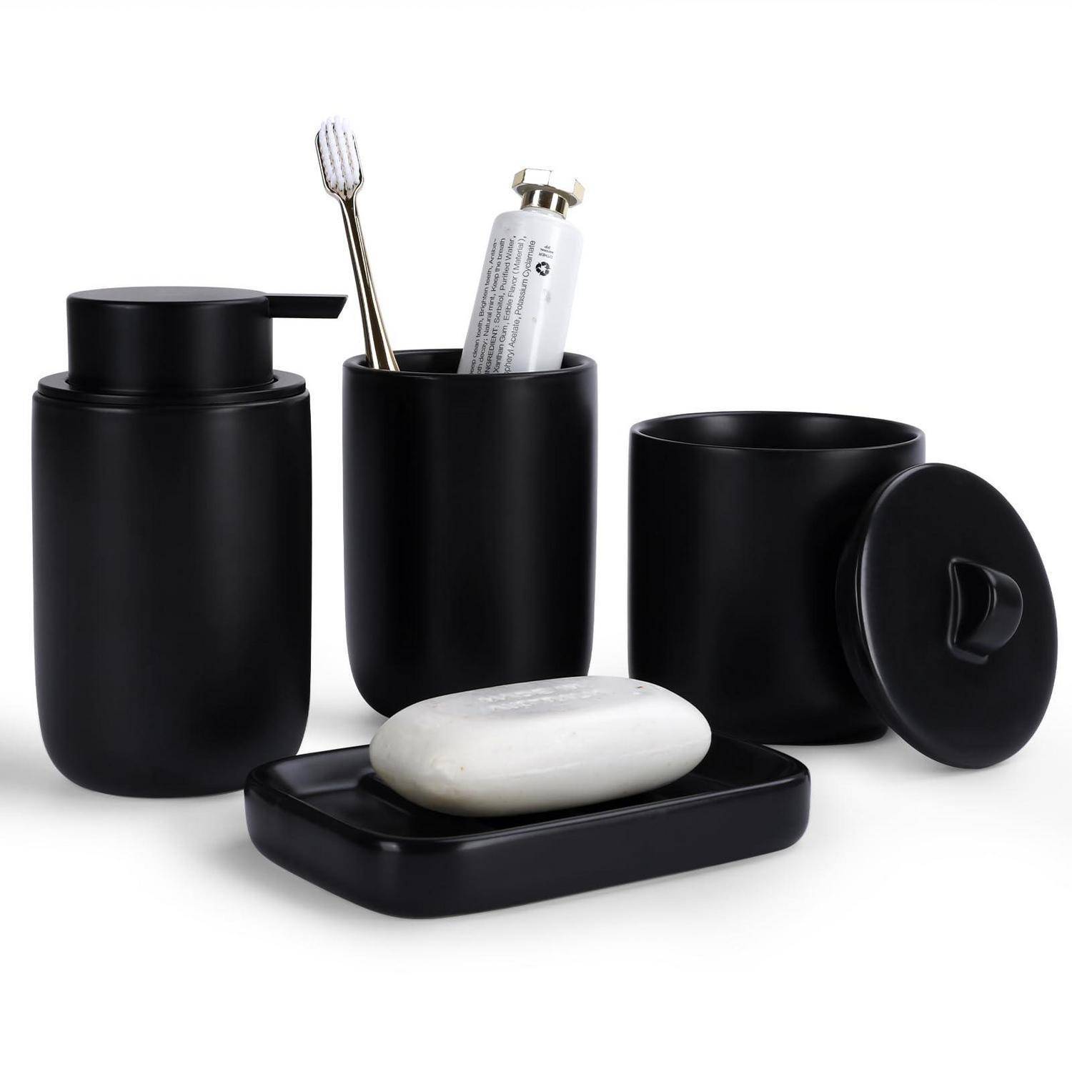 Schwarzes Badezimmer-Accessoire-Set mit Seifenspender, Zahnbürstenhalter, Becher, Seifenschale und weißer Stückseife auf weißem Hintergrund.
