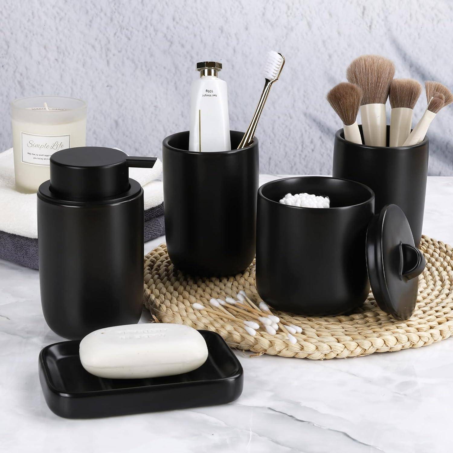 Schwarzes Badezimmer-Accessoire-Set mit Behältern mit Deckel, Zahnbürsten- und Make-up-Pinsel-Haltern, Seifenschale und Behältern, die auf einer geflochtenen Matte angeordnet sind.