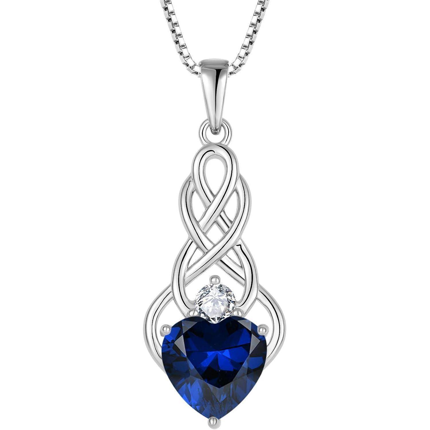 Silberkette mit verziertem tropfenförmigem Anhänger, der einen blauen herzförmigen Edelstein und einen kleinen klaren Stein darüber aufweist.