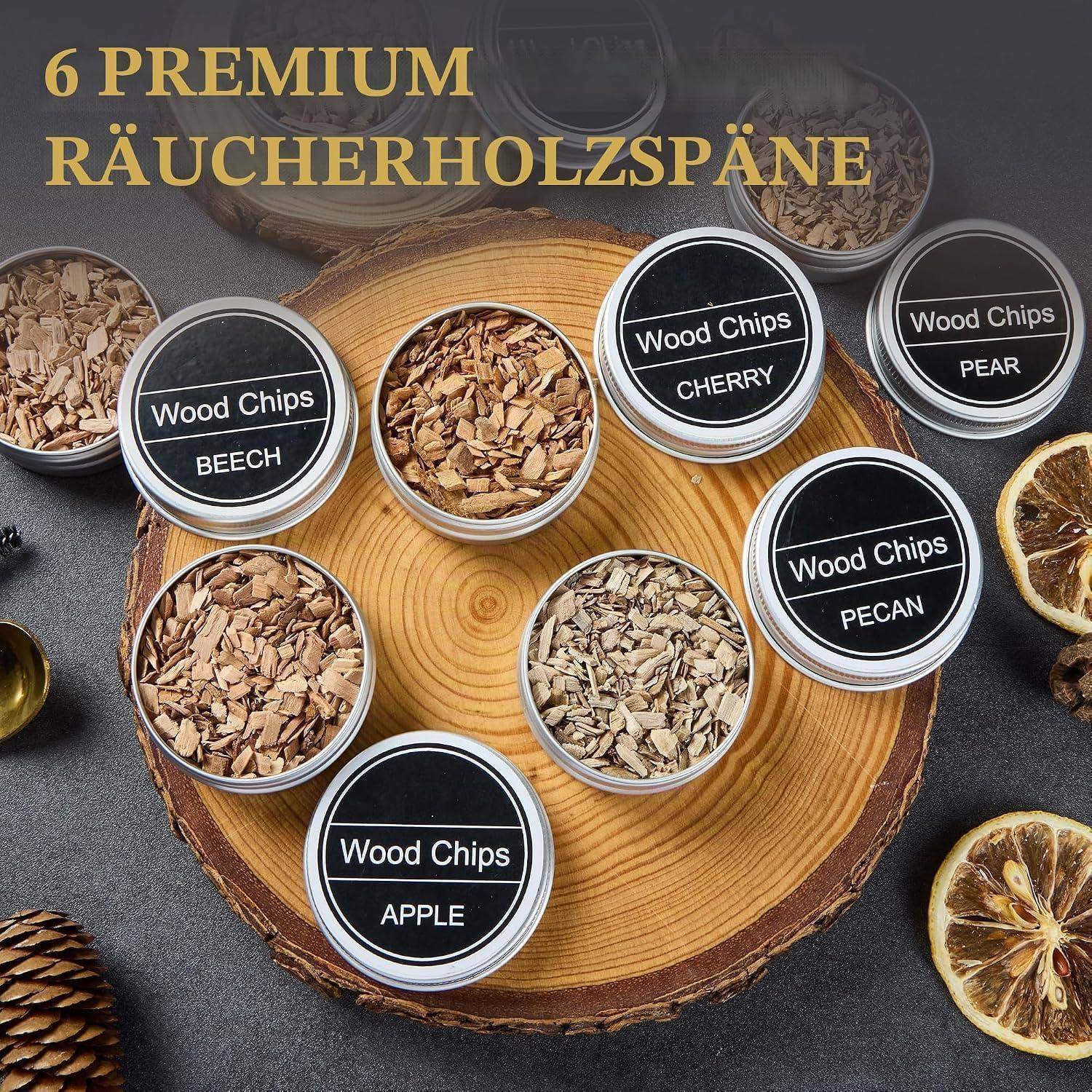 Sechs Dosen mit Premium-Räucherspänen mit den Bezeichnungen Buche, Kirsche, Birne, Pekannuss, Apfel und eine Dose ohne Beschriftung, angeordnet auf einer Holzscheibe.