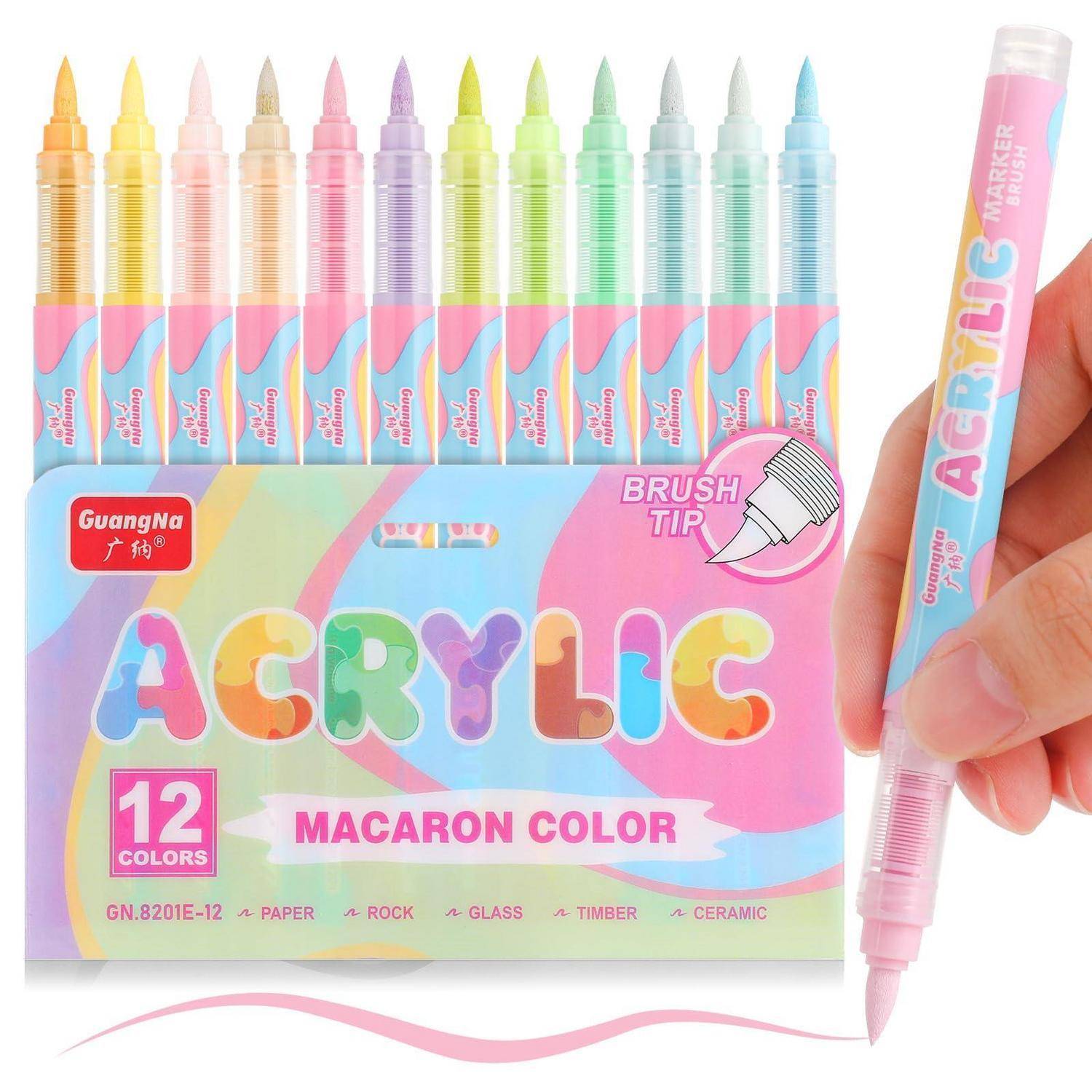 Kartonverpacktes Set mit 12 Acryl-Pinseltip-Markern in Pastellfarben; eine Hand hält einen rosafarbenen Marker mit der Aufschrift 