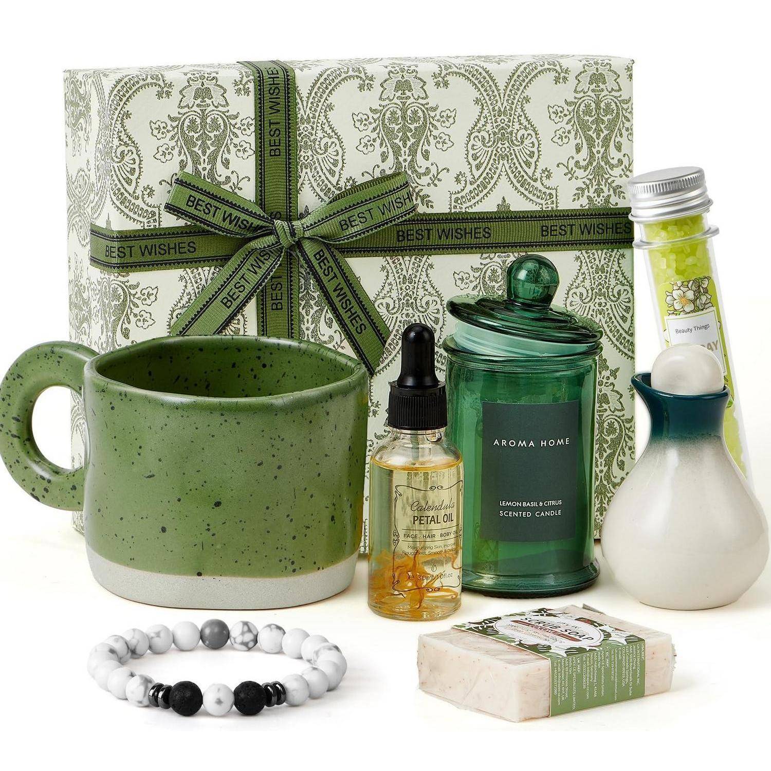 Geschenkset mit grüner Keramiktasse, duftender Kerze, Flasche ätherisches Öl, Diffusor, Badesalz und Perlenkette, verpackt in einer Box mit der Aufschrift „Beste Wünsche