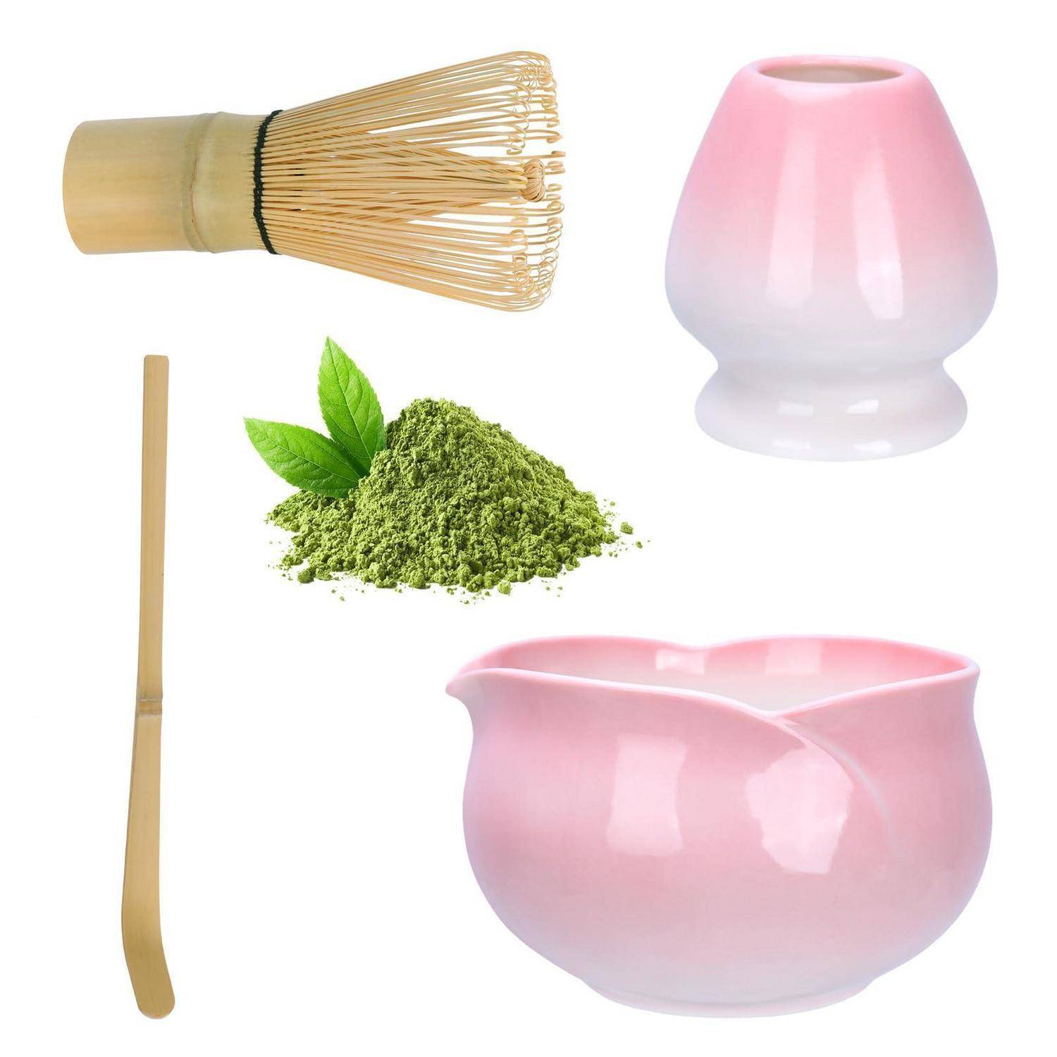 Matcha-Tee-Set mit Bambusbesenquast, Löffel, Pulver, rosa Teeschale und Bestenhalter auf weißem Hintergrund.