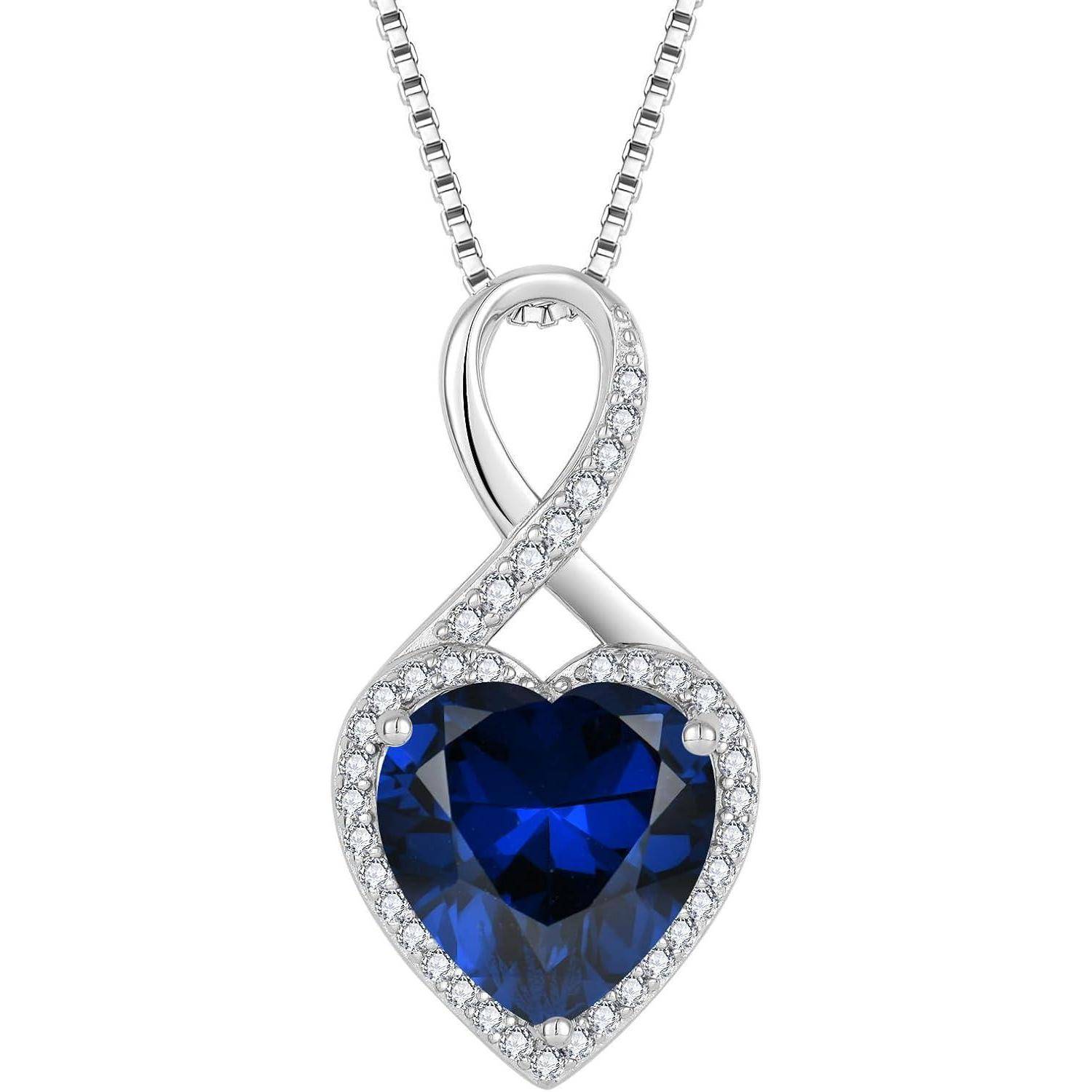 Silberner Anhängerhals mit einer Unendlichkeitsschleife und herzförmigem blauem Edelstein, umgeben von kleinen klaren Steinen.