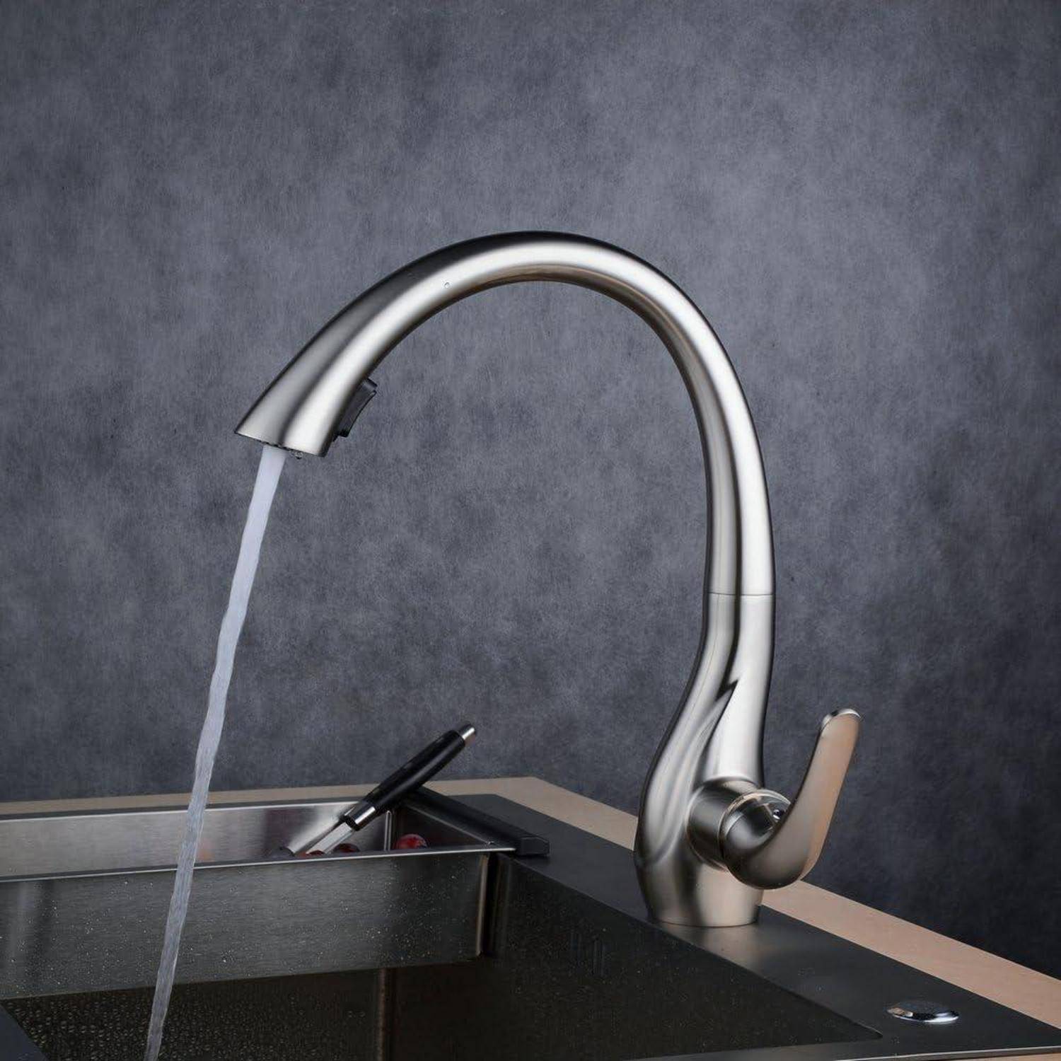 Moderner Edelstahlküchenarmatur mit fließendem Wasser in ein Spülbecken, mit einem Seifenspender in der Nähe an einer grauen Wand.