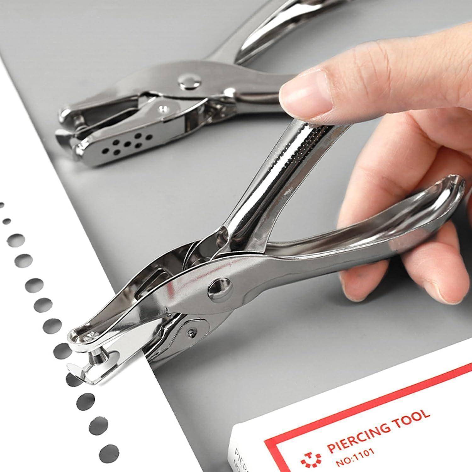Eine Hand, die ein Metallstanzwerkzeug benutzt, um gleichmäßig verteilte Löcher in Papier zu stanzen; ein weiteres ähnliches Werkzeug und eine Produktschachtel mit der Aufschrift „STANZWERKZEUG" sind sichtbar.
