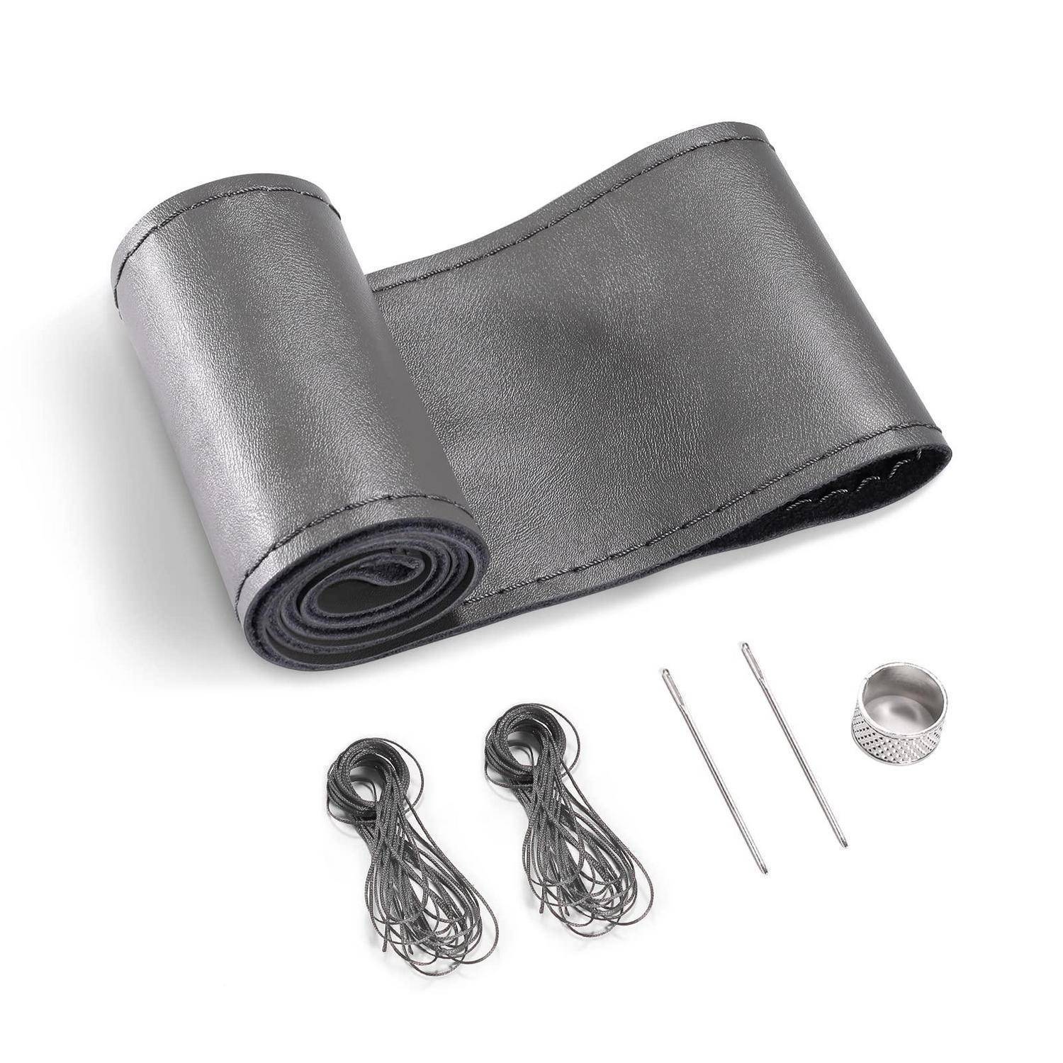 Graugraue, lederähnliche Wicklung mit zwei Bündeln schwarzer Schnüre, zwei Metallnadeln und einem Fingerhut zum Nähen oder Reparieren.