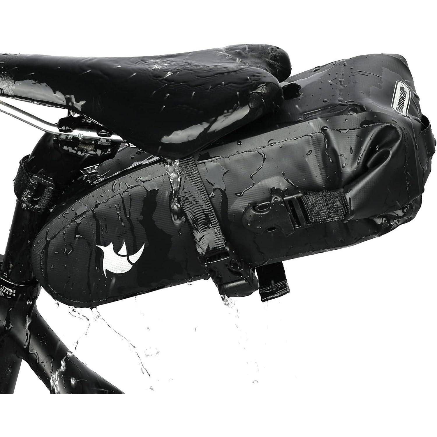 Schwarze wasserdichte Fahrradsatteltasche unter einem Fahrradsattel befestigt, bedeckt mit Wassertropfen, mit Riemen und reflektierendem Logo.