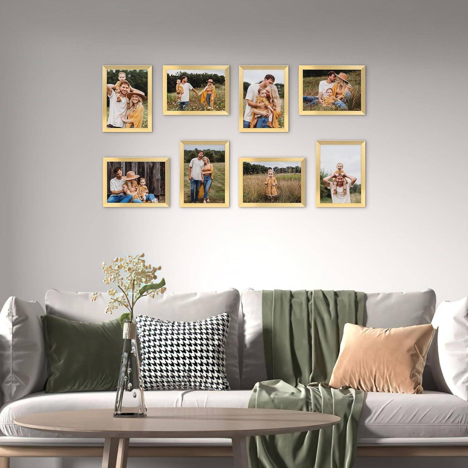 Wohnzimmer mit einem grauen Sofa, einem Couchtisch und gerahmten Familienfotos, die als Galeriewand darüber angeordnet sind.