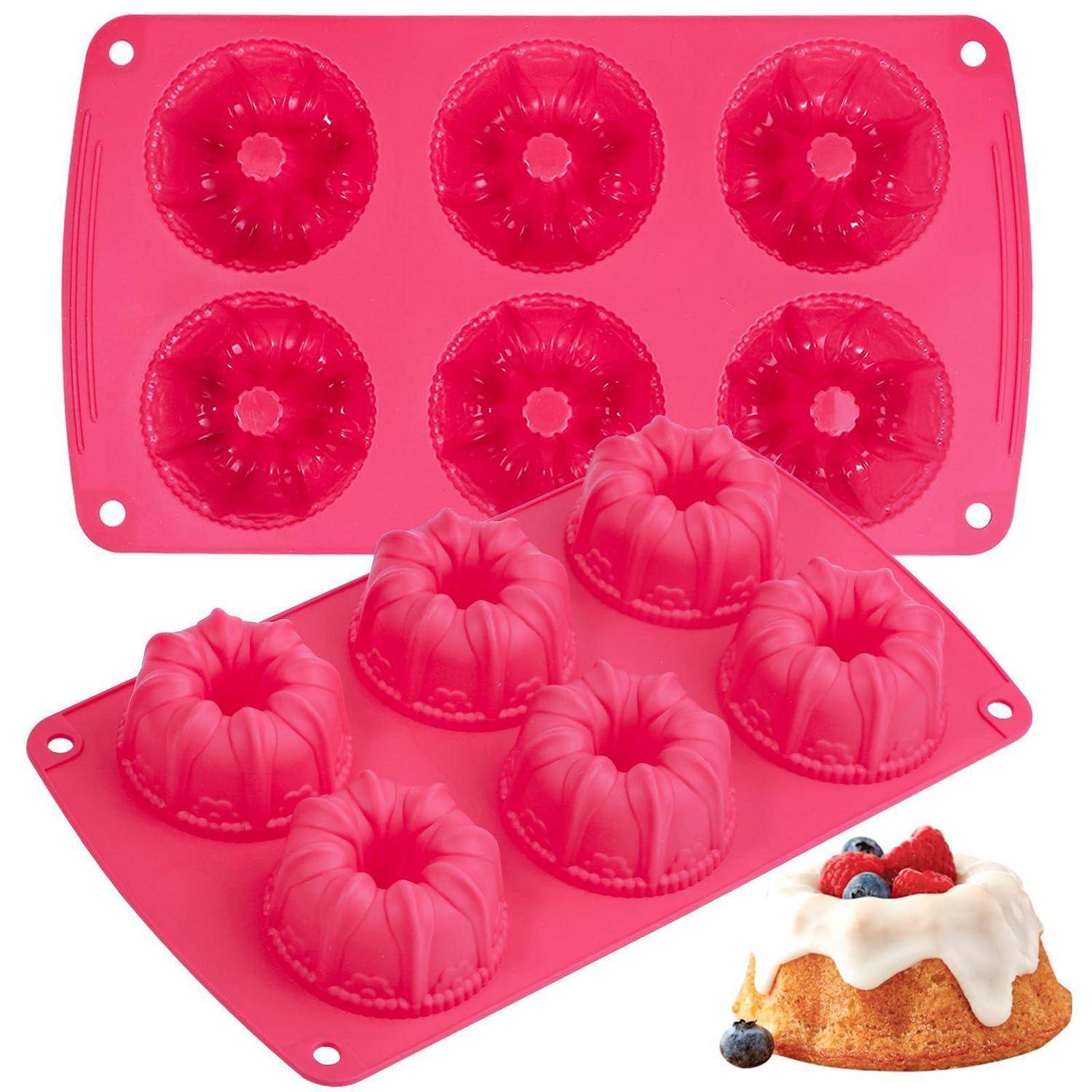Rosa Silikon-Backform mit sechs gerillten Kuchenmulden, abgebildet mit einem gebackenen Mini-Gugelhupf, verziert mit Zuckerguss und Beeren.