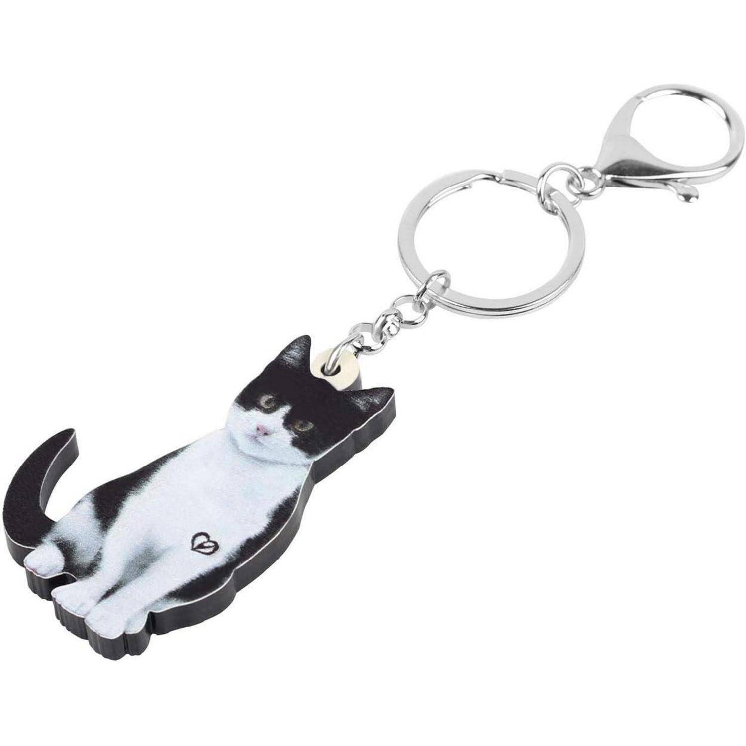 Katzenförmiger Schlüsselanhänger mit einem schwarzweißen Katzenanhänger, der an einem Metallschlüsselring und einer Verschlussvorrichtung befestigt ist.