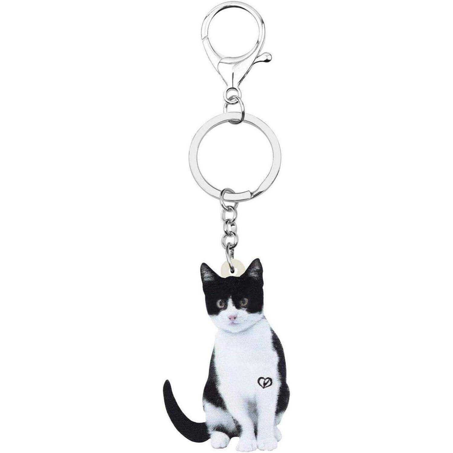 Katzenförmiger Schlüsselanhänger mit einem schwarzweißen Katzen-Charm, der von einem Metallschlüsselring und einer Verschlussfeder hängt.