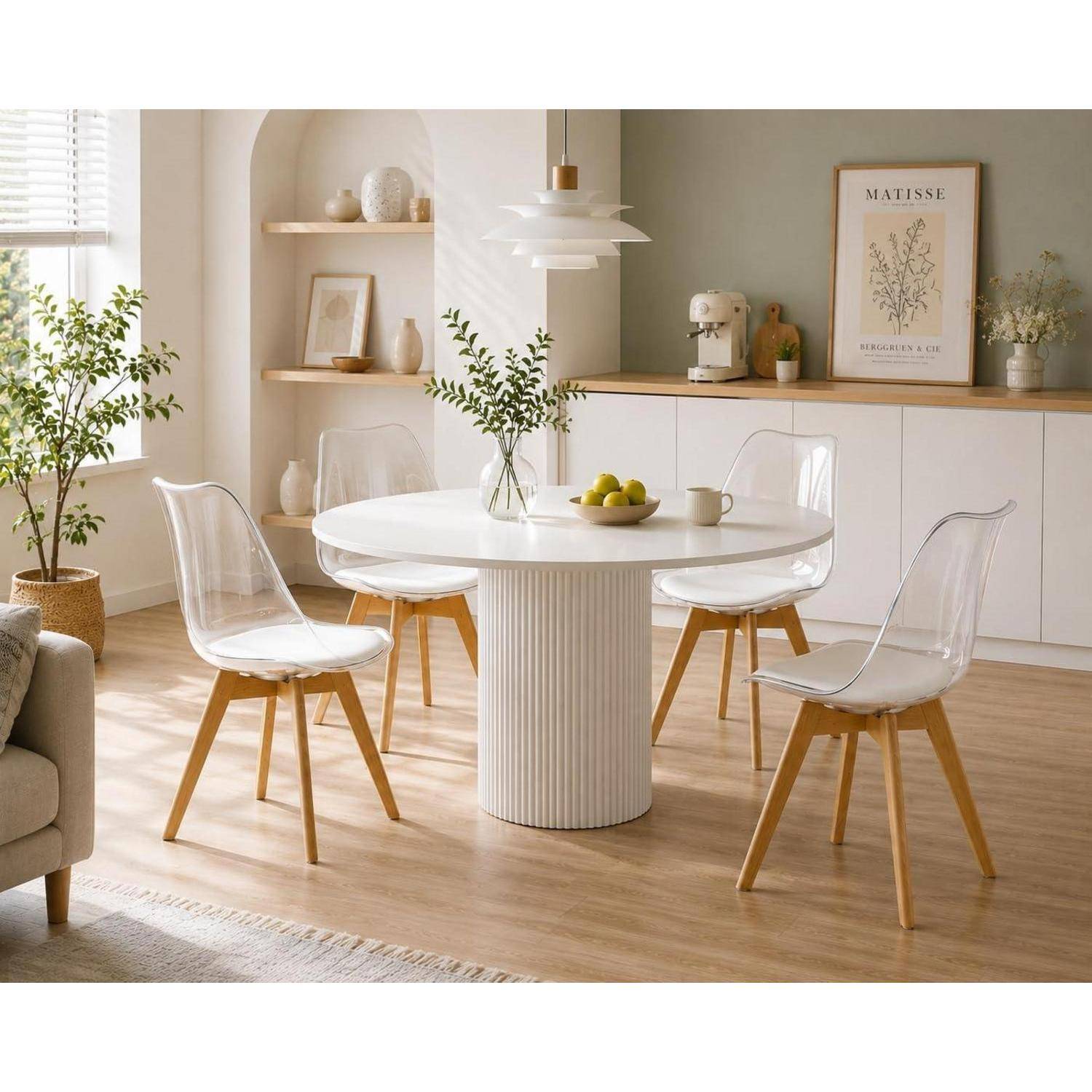 Helles modernes Esszimmer mit rundem weißem Tisch, vier transparenten Stühlen, hellem Holzboden, Regalen und minimalistischer Einrichtung.