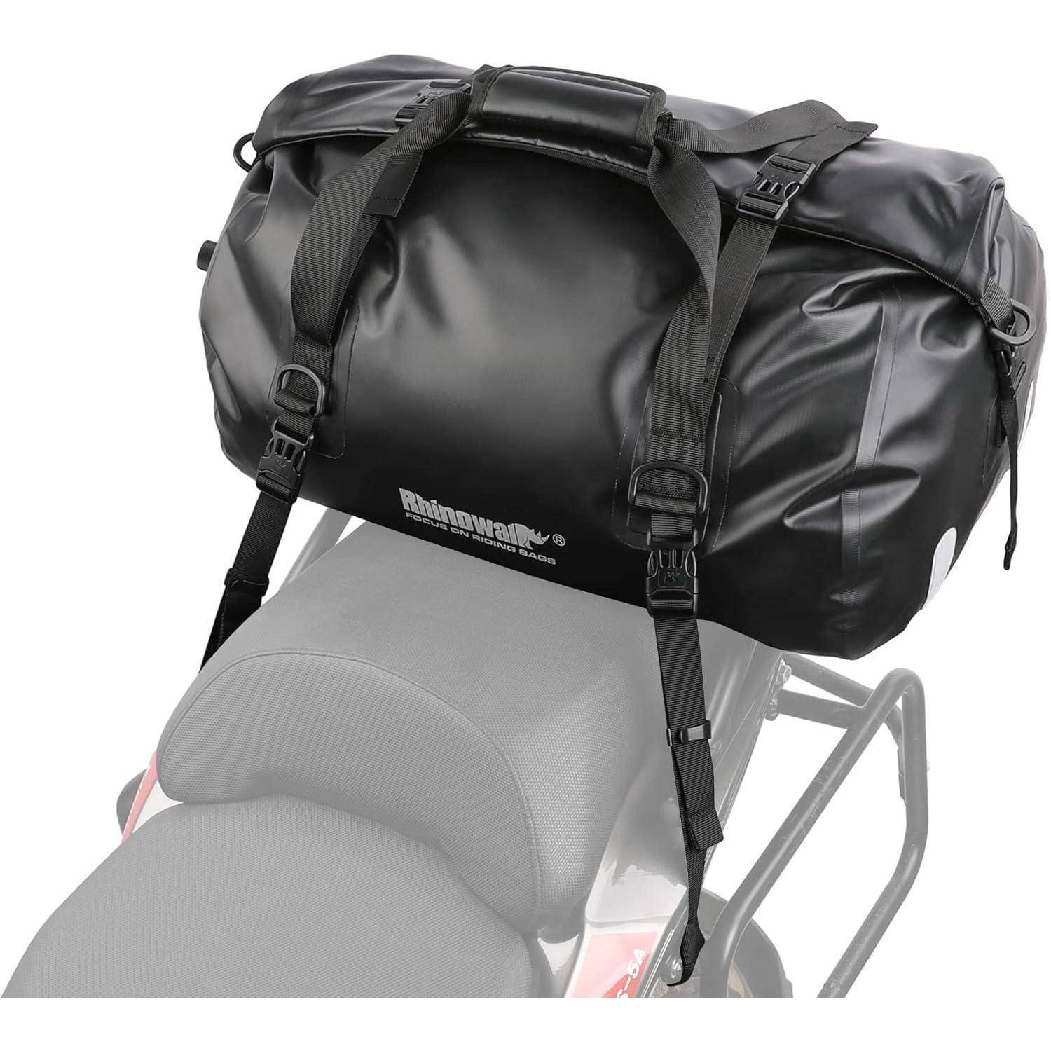 Schwarze wasserdichte Reisetasche mit Riemen, die über einem Motorradsattel befestigt sind, gezeigt im Einsatz als Motorradgepäck.