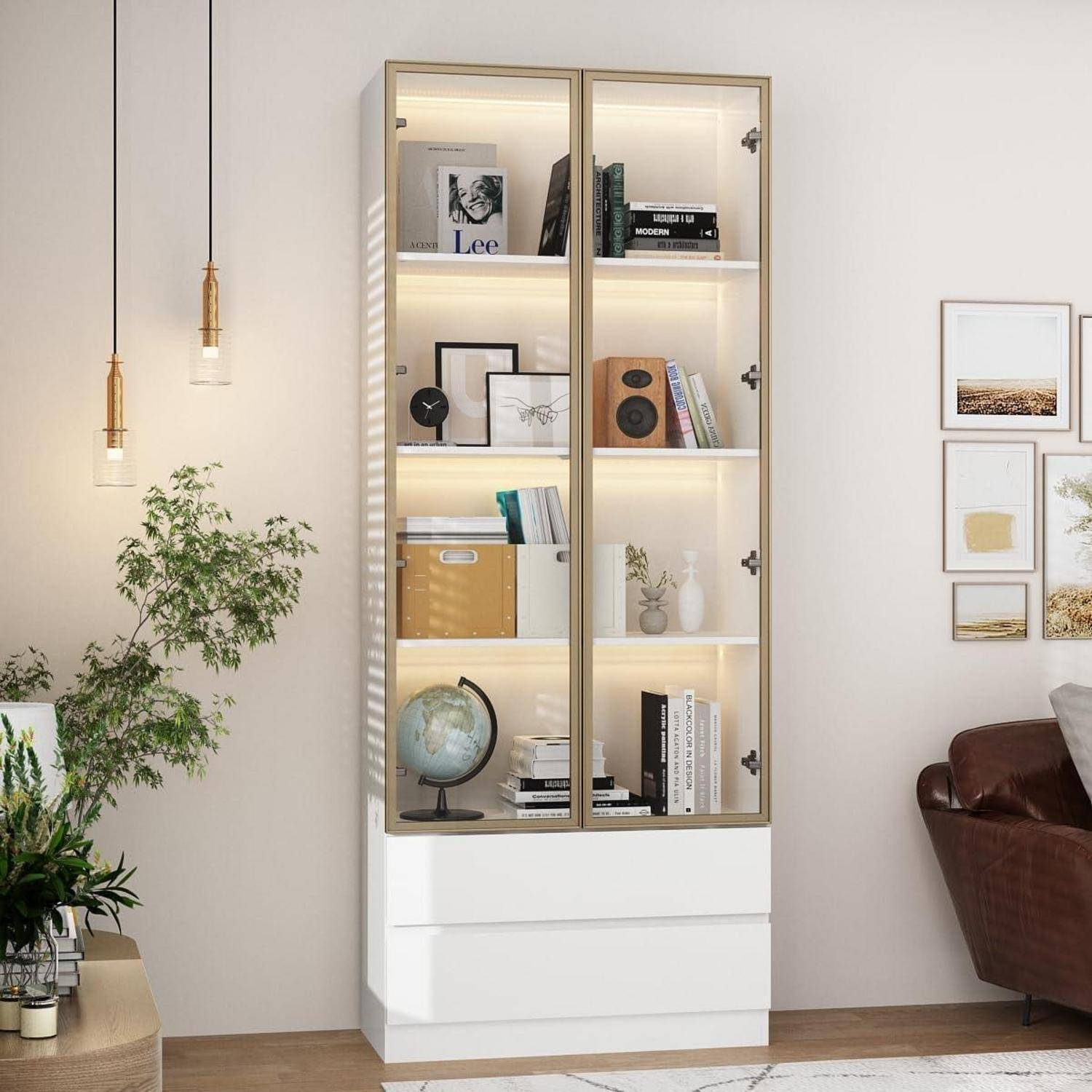 Hoher beleuchteter Glaskabinett mit Büchern, Dekoration, Globus und Schubladen zur Aufbewahrung in einem modernen Wohnzimmer neben einem Sofa und Wandkunst.