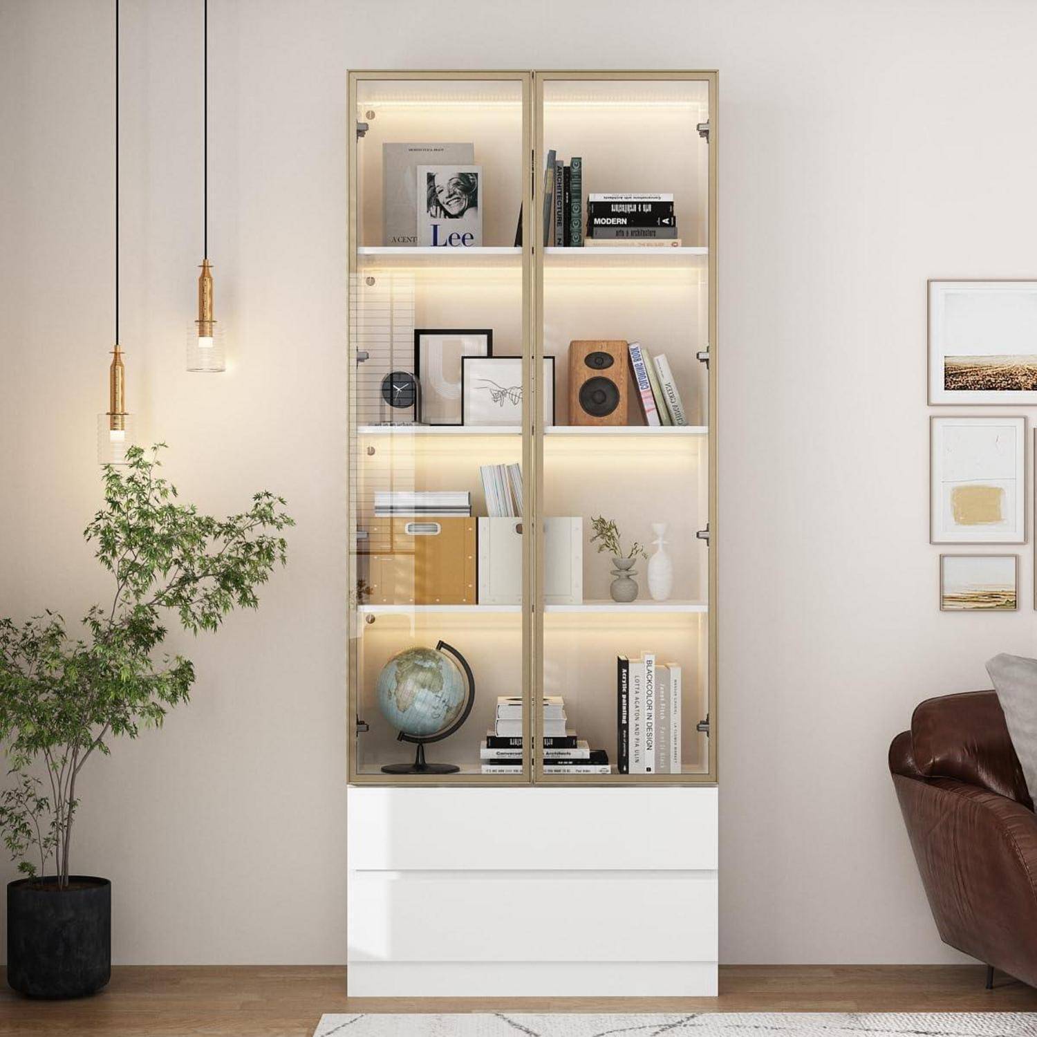 Modernes Wohnzimmer mit einer beleuchteten Glastür-Vitrine, die Bücher, Rahmenkunst, einen Globus und Dekorationsgegenstände enthält, neben einem Topfbaum und einem Lederstuhl.