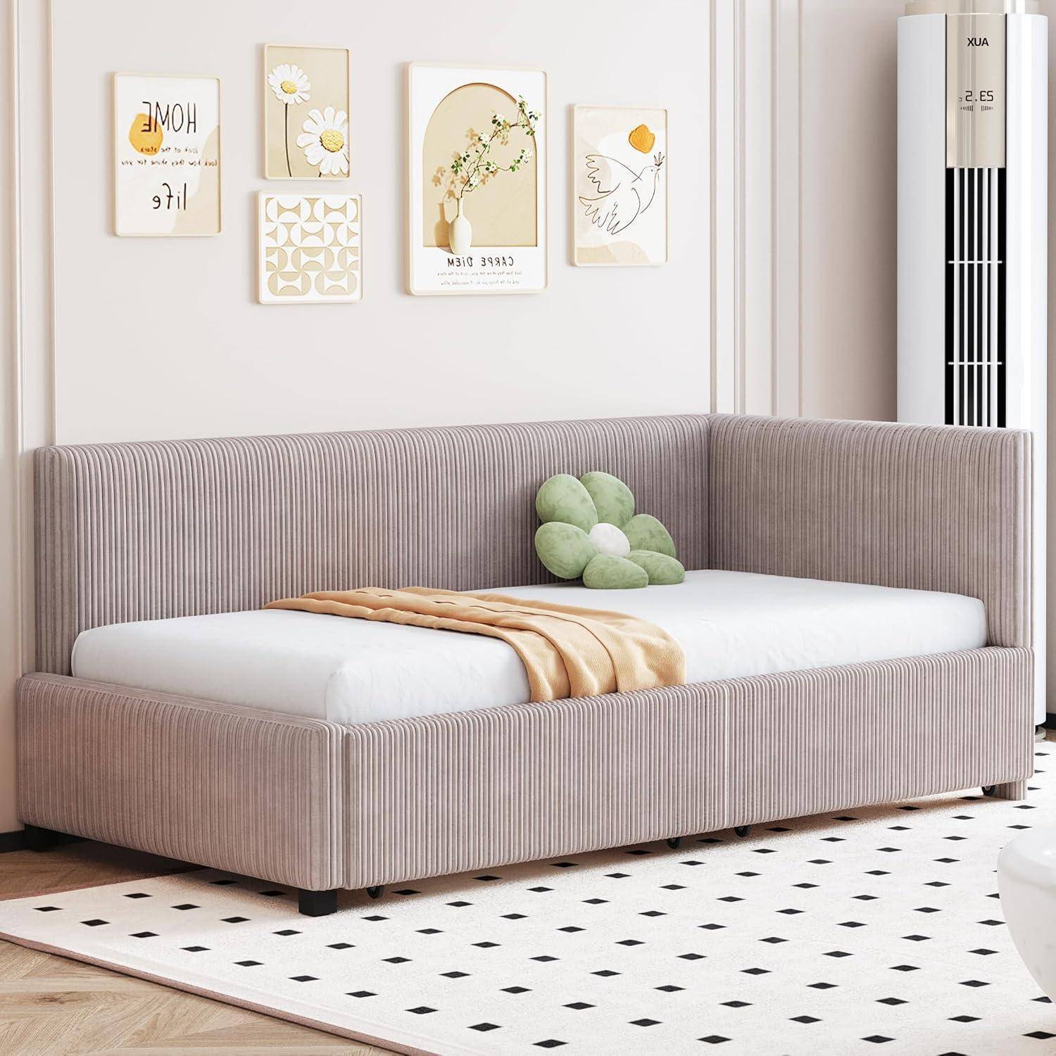 Minimalistisches Schlafzimmer mit einem taupefarbenen Tagesbett mit Polsterung, beigem Wurftuch, grünem Kissen und vier botanischen Wanddrucken darüber.