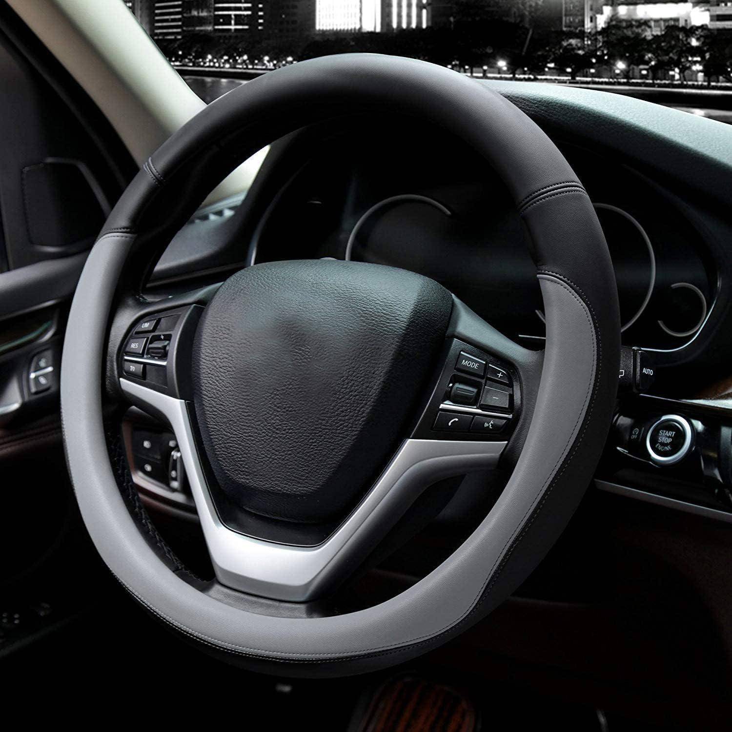 Nahaufnahme eines modernen Autolenkrads mit integrierten Steuertasten und einer Push-Start-Zündung auf dem Armaturenbrett.