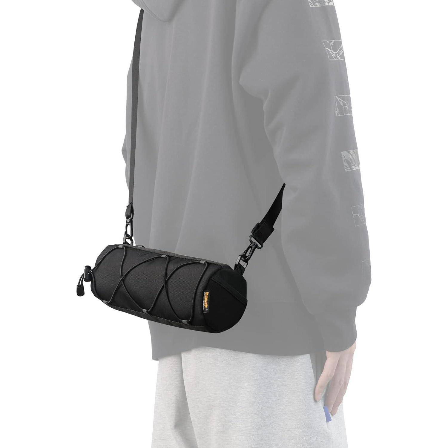 Person, die eine schwarze zylindrische Umhängetasche mit verstellbaren Riemen über einem grauen Sweatshirt und heller Hose trägt