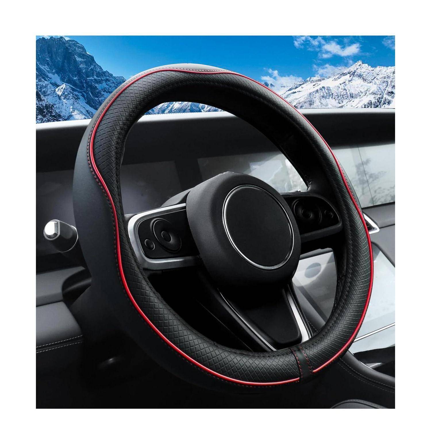 Nahaufnahme eines Autolenkrads mit roter Verkleidung im Inneren eines Fahrzeugs, mit schneebedeckten Bergen sichtbar durch die Windschutzscheibe.