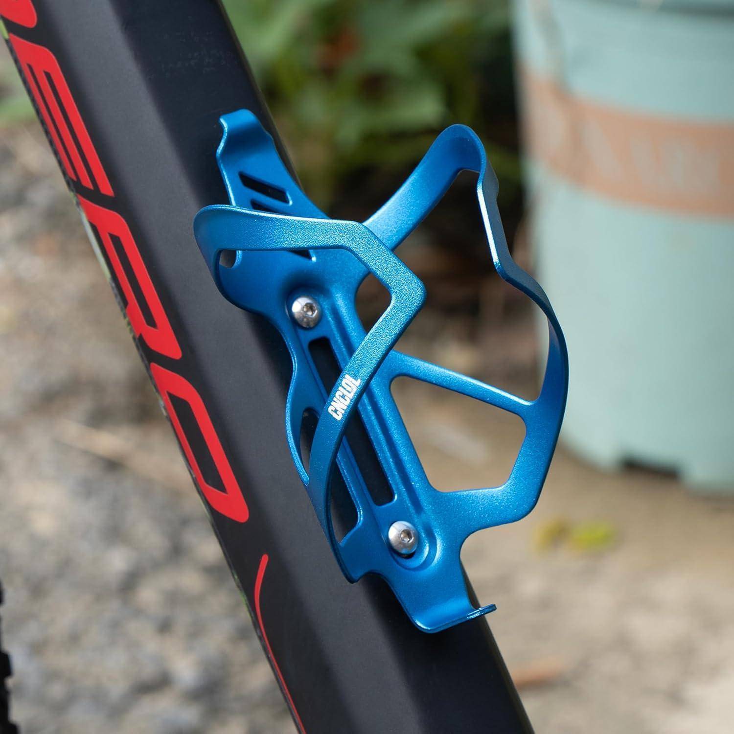 Blauer Fahrradwasserflaschenkäfig auf einem schwarzen Fahrradrahmen mit roter Beschriftung montiert.