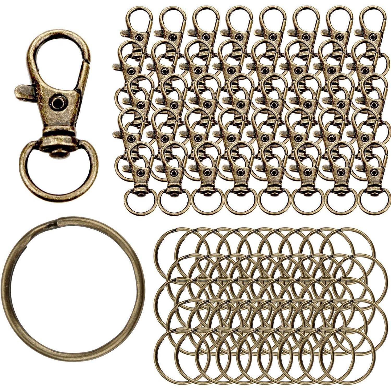 Assortiertes antikes Messingkeychain-Zubehör: Hummerklauen, Spaltrihringe und mehrere Schlüsselringe in Gruppen auf weißem Hintergrund angeordnet.