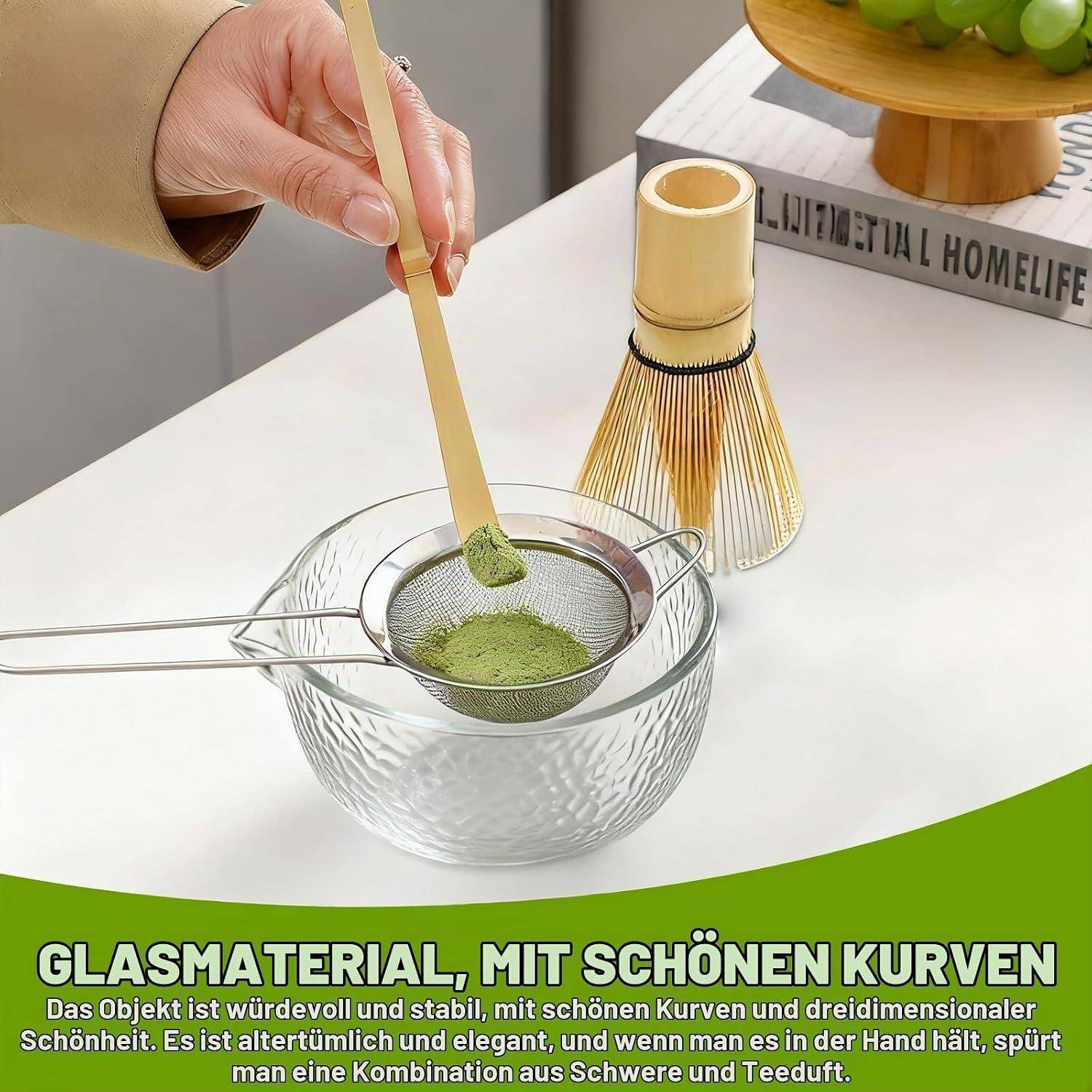 Grünes Matcha-Pulver durch ein Sieb in eine Glasschüssel geben, ein Bambusquast liegt in der Nähe; Deutsche Anzeige bewirbt 'GLASMATERIAL, MIT SCHÖNEN KURVEN' und elegantes Design.