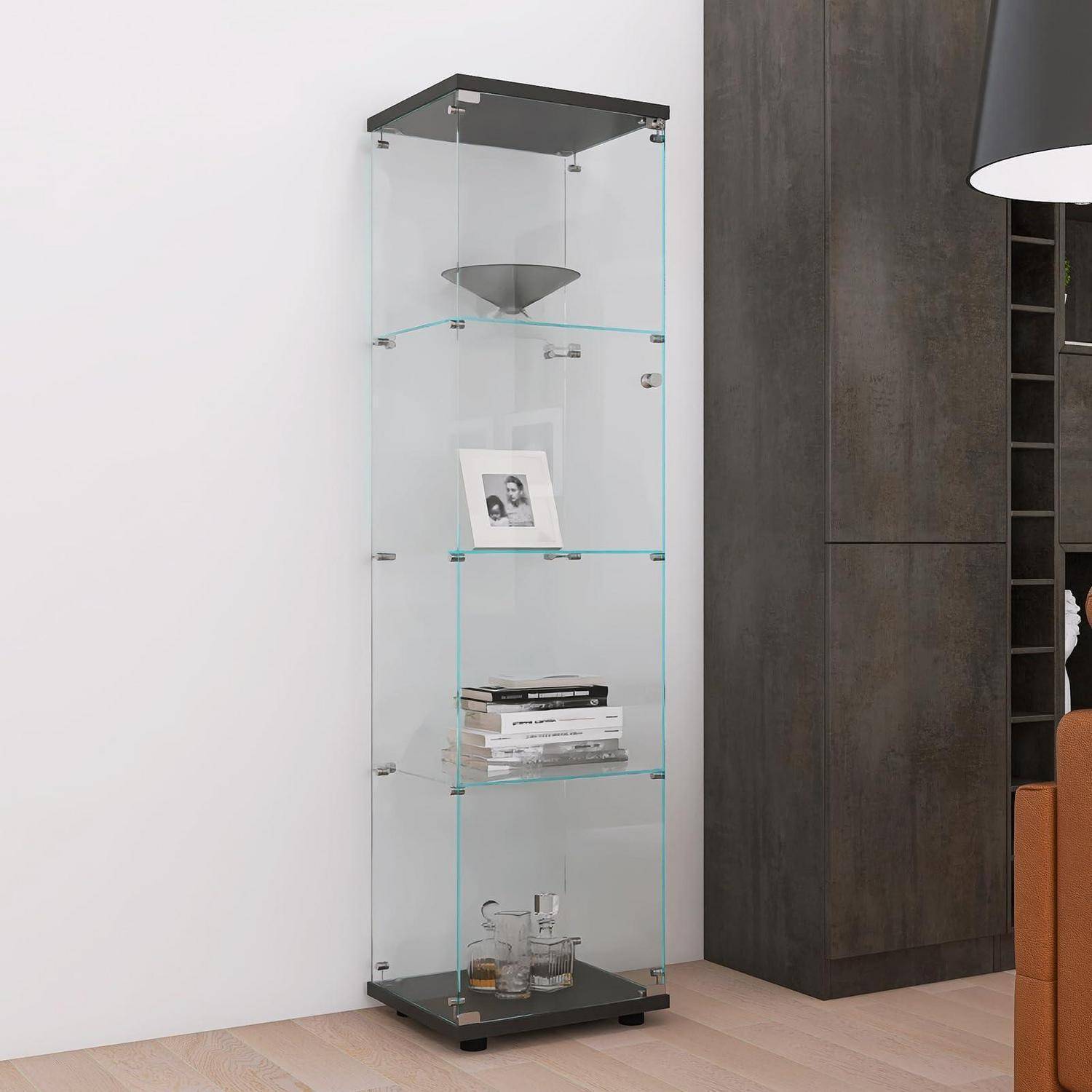 Hoher gläserner Vitrinenschrank mit vier Regalen, auf denen eine Schüssel, ein gerahmtes Foto, Bücher und Glaswaren in einem modernen Zimmer stehen.