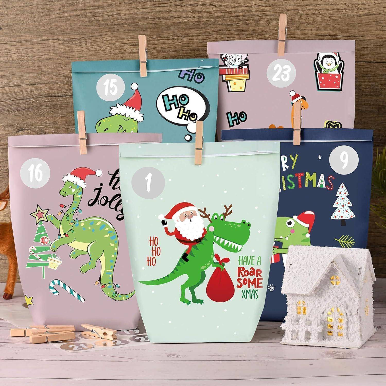Bunte Weihnachts-Adventskalender-Geschenktüten nummeriert 1, 9, 15, 16 und 23 mit Cartoon-Weihnachtssauriern, plus eine kleine leuchtende weiße Hausdekoration.