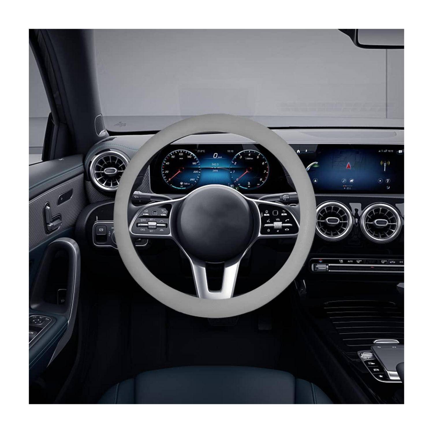 Modernes Autoinnenraum mit einem hellen Lenkrad, digitales Kombiinstrument, duale Mittellüftungsschlitze und Armaturenbrettsteuerungen.