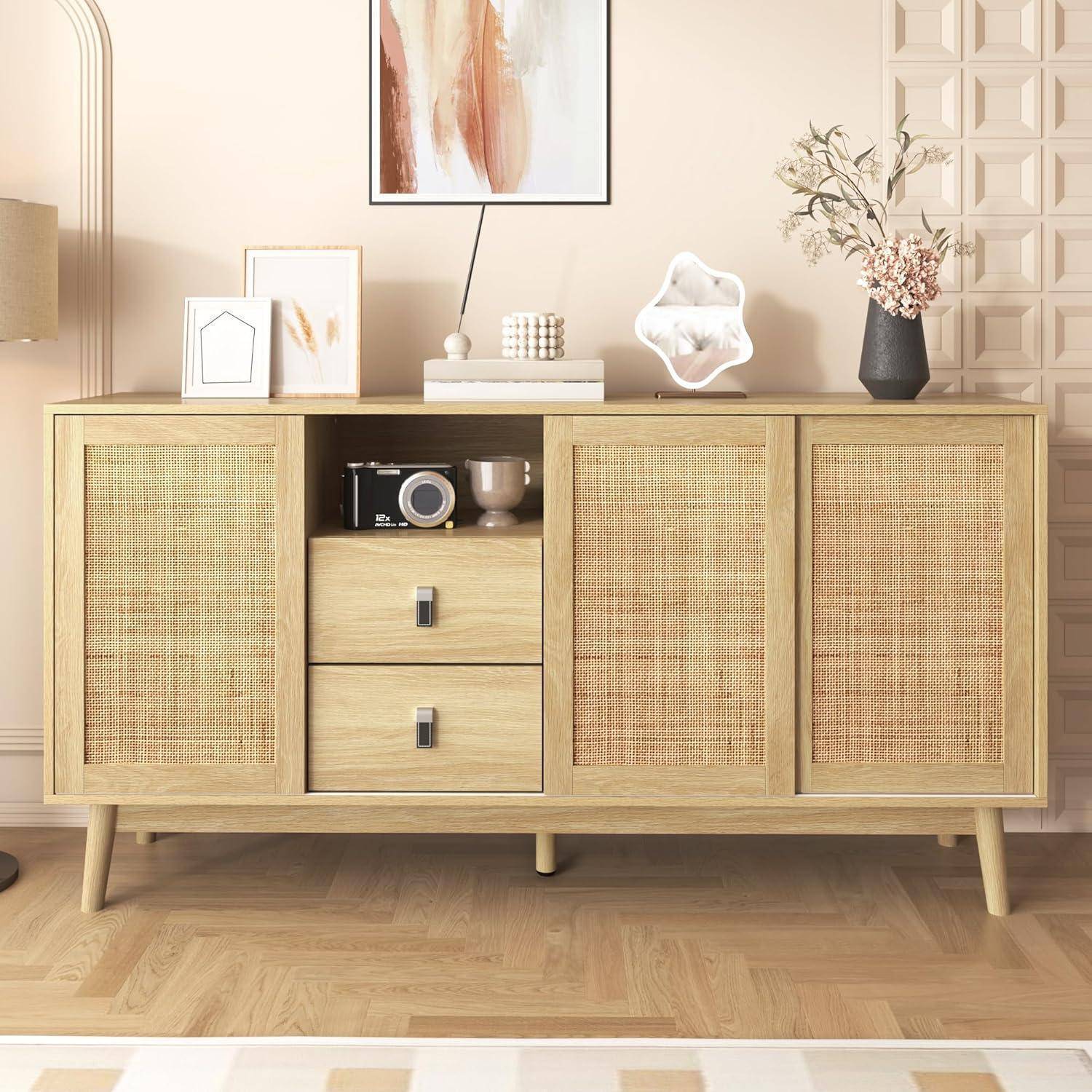 Helles Holz-Sideboard mit Rattanfront-Türen und Schubladen, stilisiert mit Rahmenkunst, Lampe, Vase und Dekorationsobjekten in einem hellen Raum.