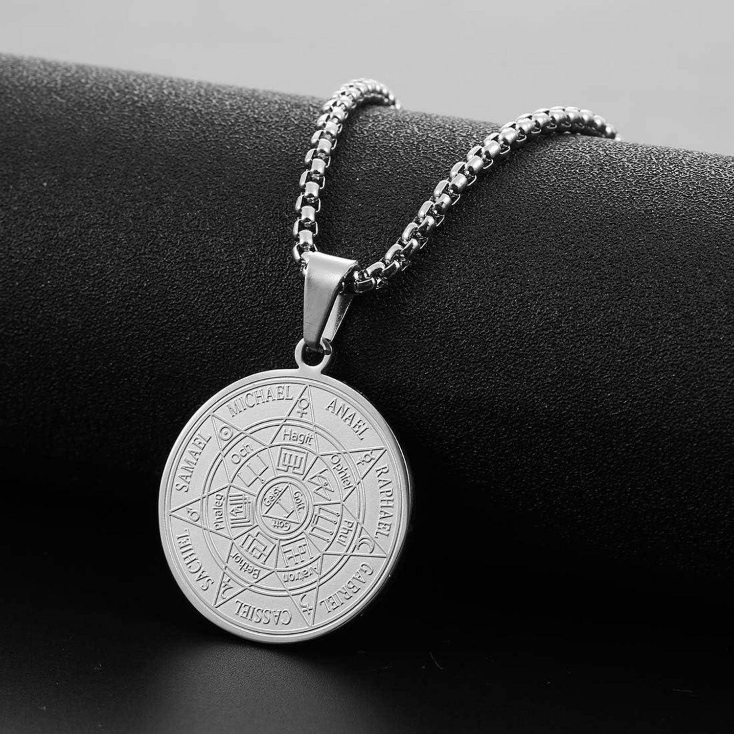 Silberne Anhängerkette mit gravierter runder Medaille und Kette auf schwarzem Ständer.